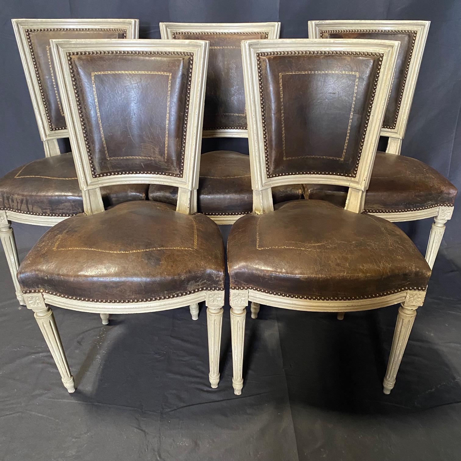 Antique French set of six painted Louis XVI dining chairs sourced from Provence, France. Each chair has a hand-crafted frame, featuring square-shaped back hand-painted with a creamy white finish showcasing a naturally aged patina. The chairs have