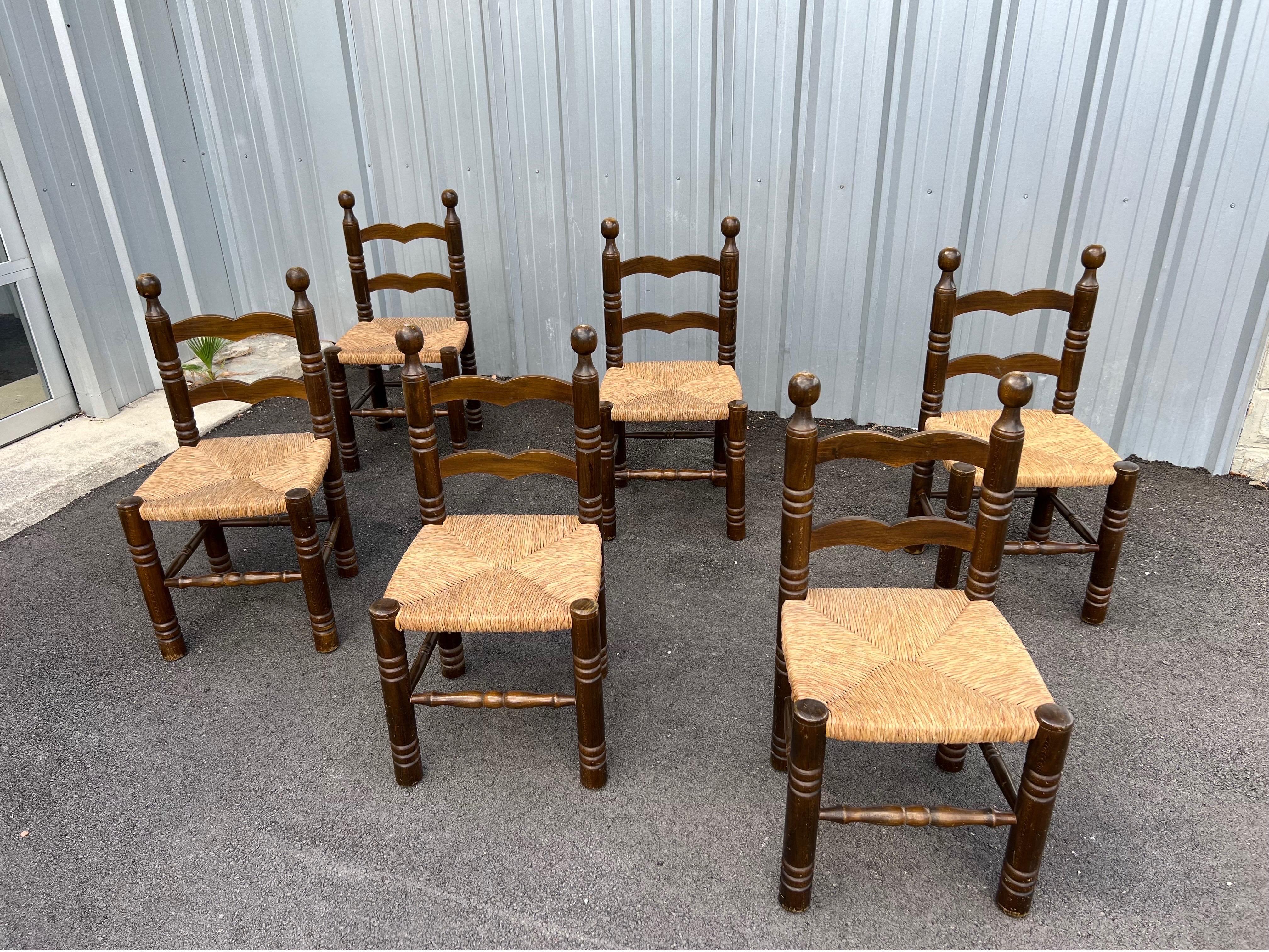 Set of 6 mid-century brutalist dining chairs in the manner of Charles Dudouyt, France, circa 1960s. These vintage dining chairs are made of stained oak with woven cording. These are in good overall condition.