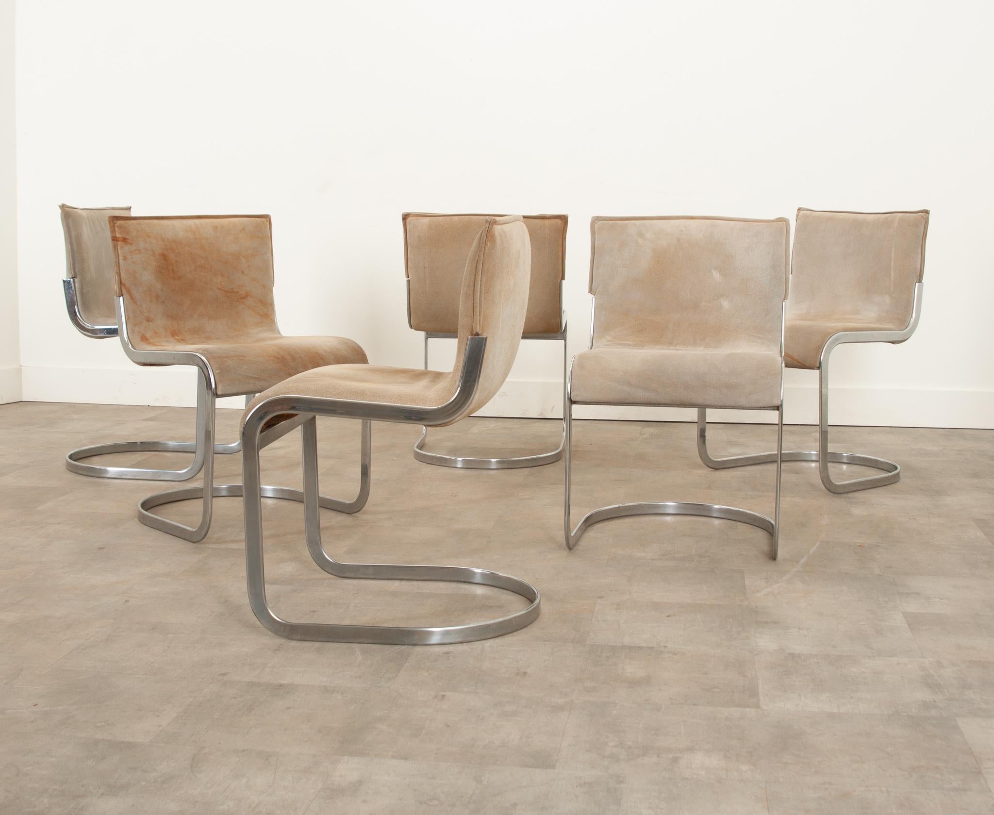 This no-frills set of six Mid-Century Modern cantilever chairs are a wonderful addition to any dining space for their comfort and functional design. The well loved suede has staining that adds a ton of character. The chrome frames are a great