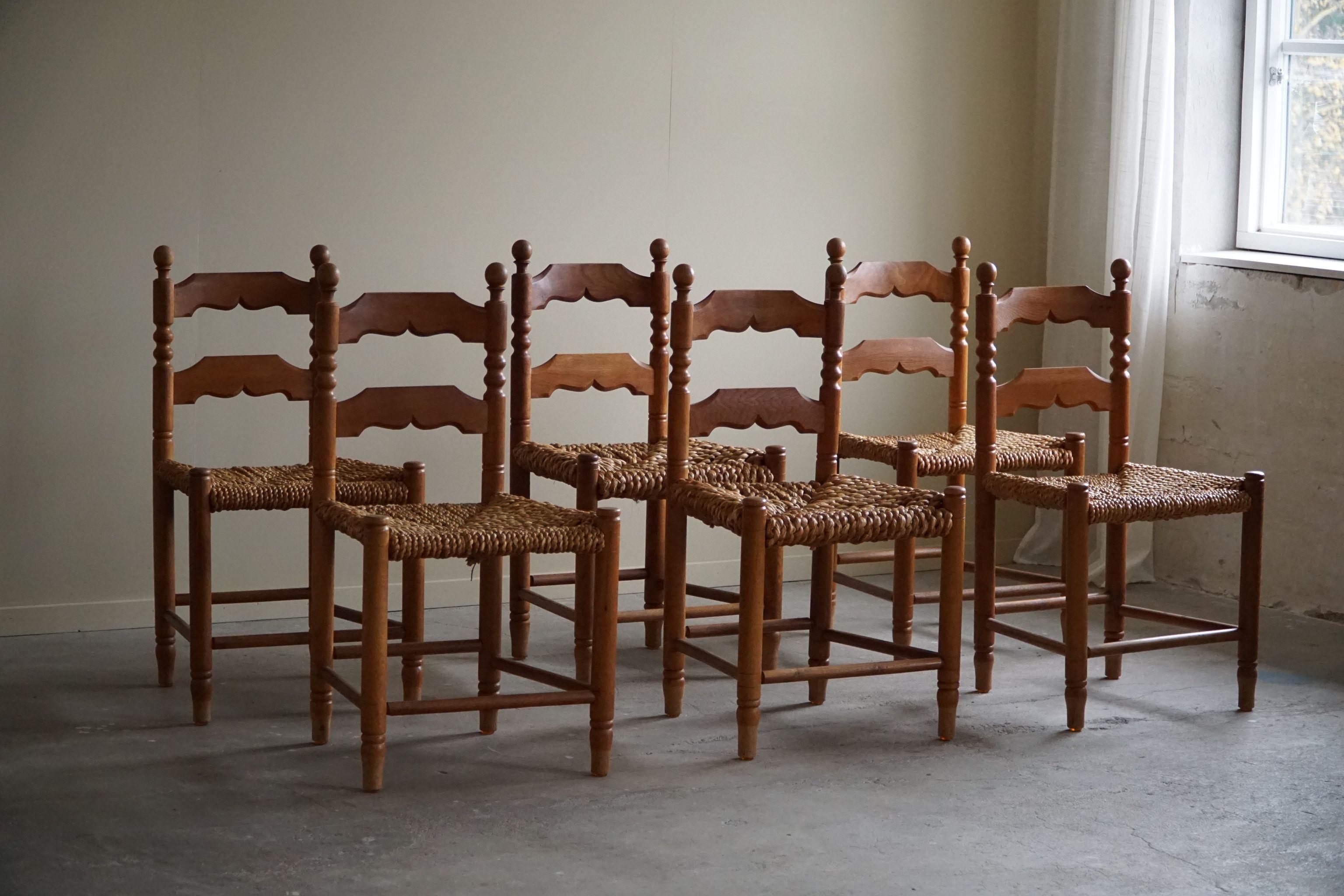 Set of 6 brutalist dining chairs in solid oak & hand woven seats of seagrass(notice 2 types of seagrass). Made by a French cabinetmaker in the 1950s. A great sculptural design that match many interior styles. 

These chairs are in a good vintage