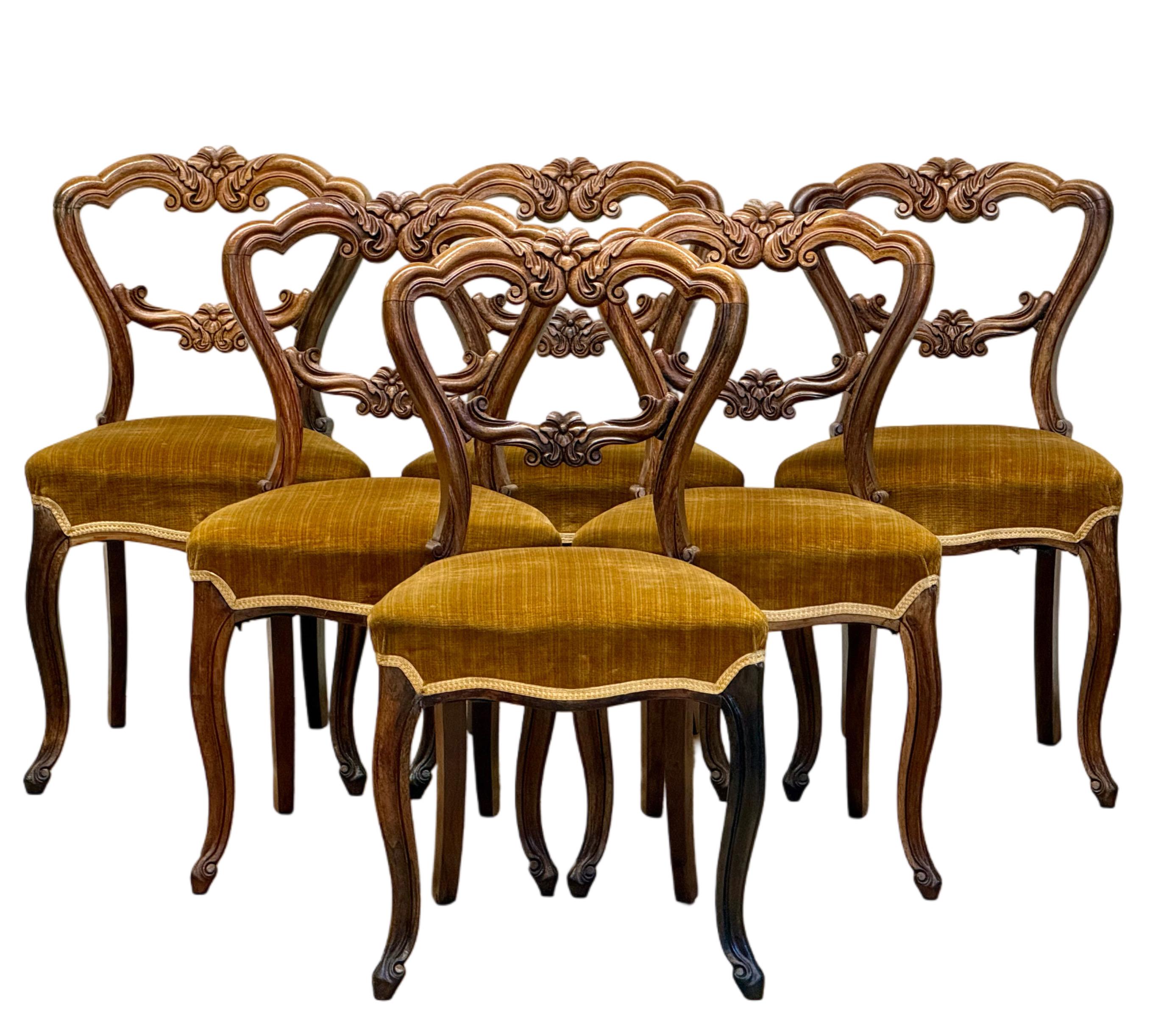 A set of six Fine French Rosewood Antique side chairs, dating from the mid to late 19th century (1850-1880), during the Second Empire period. These chairs feature elegant balloon backs with intricate carvings and scrolling details, showcasing the