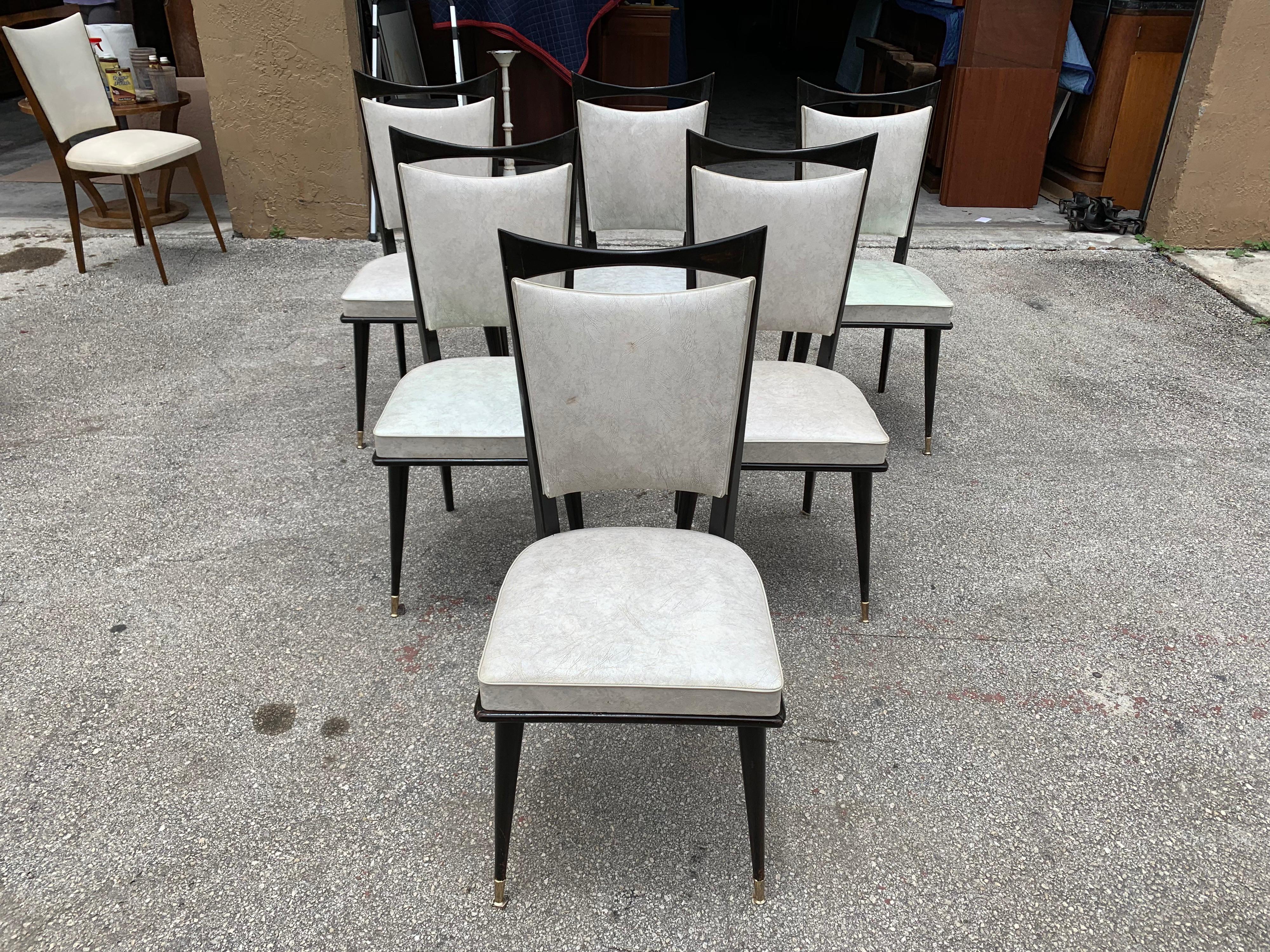 Classic set of six French vintage dining chairs solid mahogany, circa 1940s, the two front feet are capped with brass. The chair frames are in excellent condition. The Reupholstery is vinyl recommended to be change for all 6 dining chairs, the