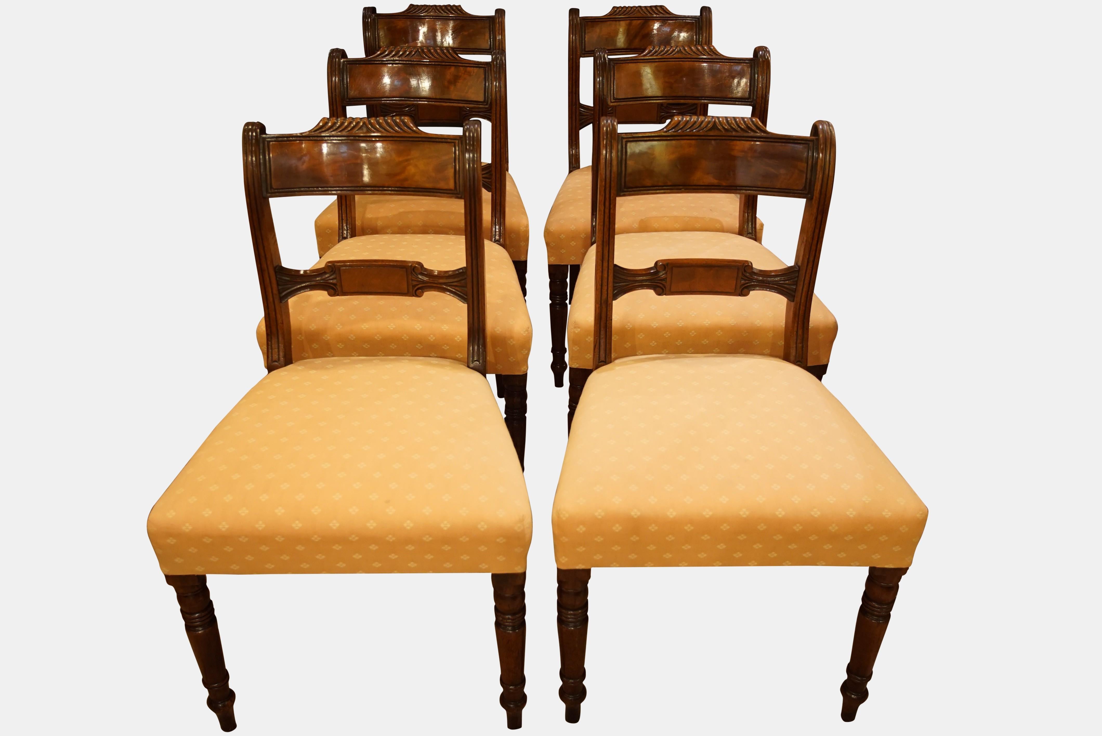 A set of 6 George IV mahogany dining chairs with finely turned legs and bar backs and overstuffed seats,


circa 1830.