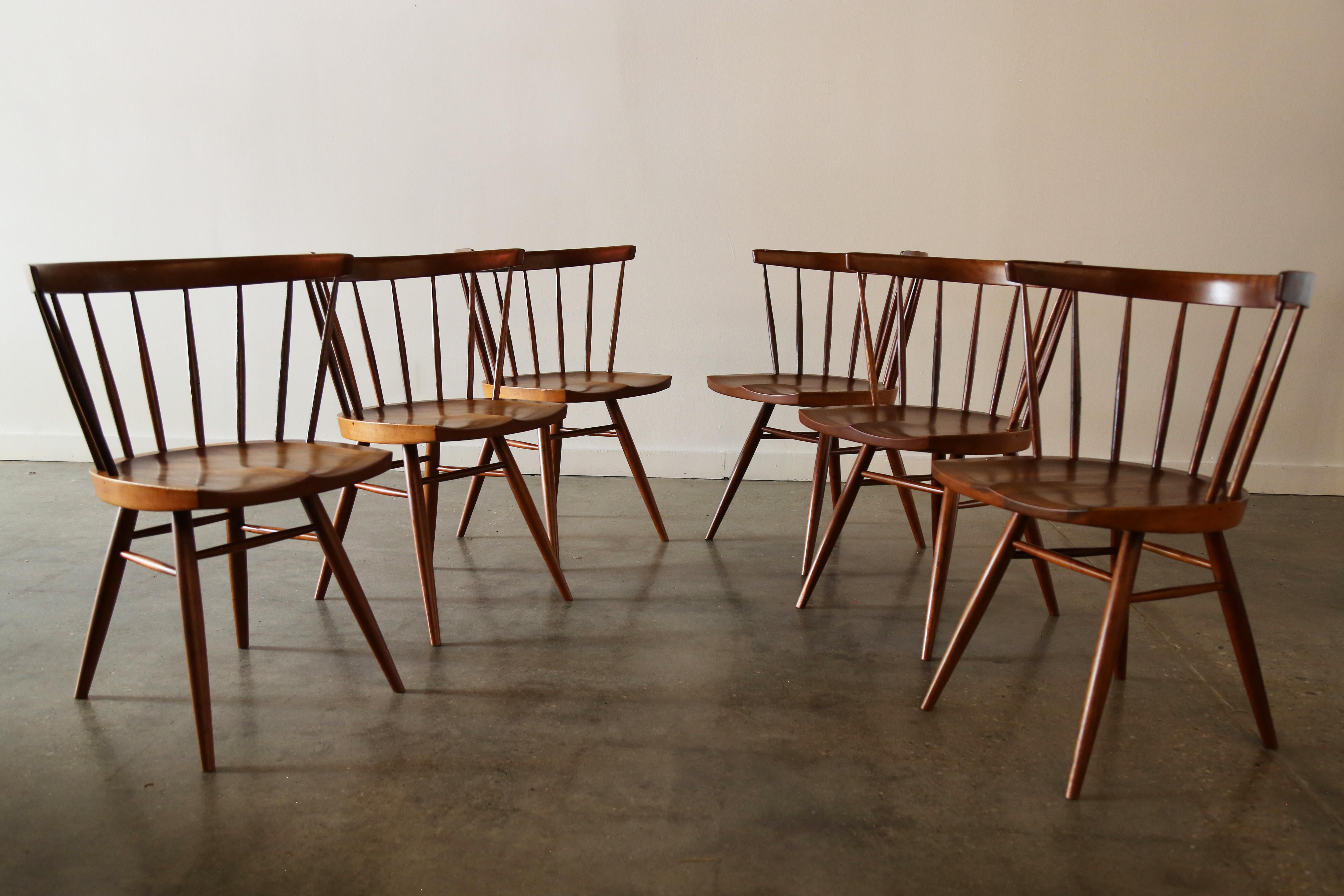 Ein Satz von 6 Stühlen mit gerader Rückenlehne, entworfen von George Nakashima Studios, ca. 1960er Jahre. Die handgeschnitzten Spindeln, die geformte Sitzfläche, die eingekerbten Füße an der Unterseite der 4 gedrechselten Beine, die