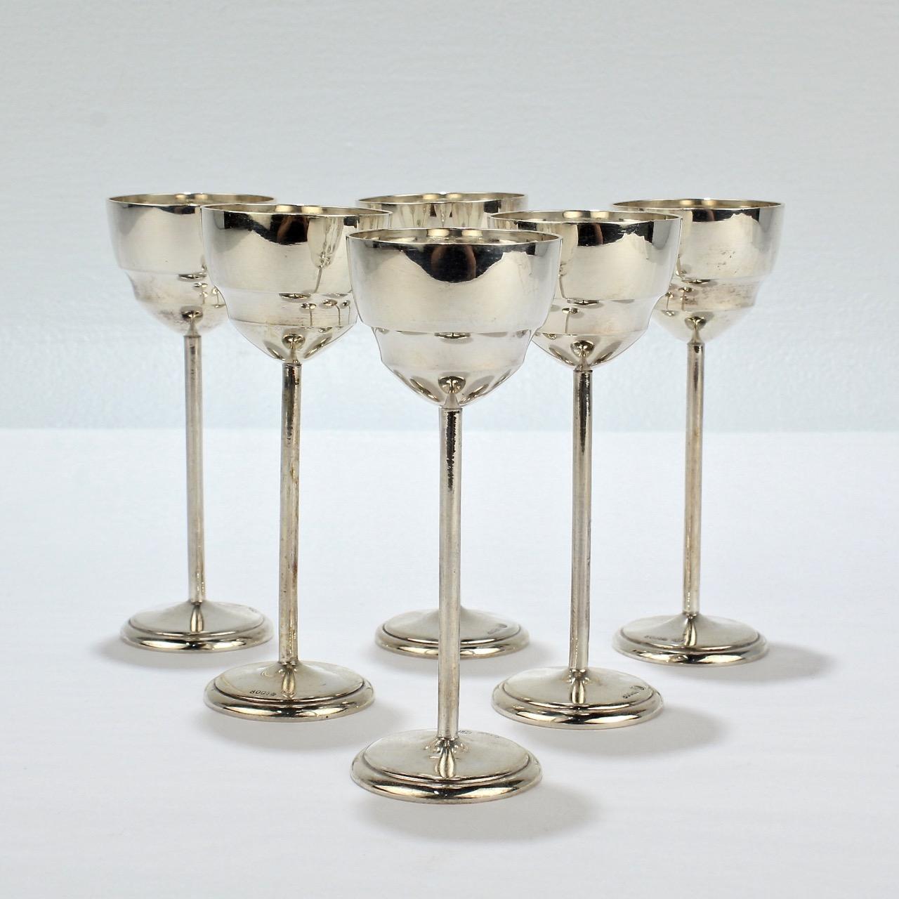 A fine set of 6 Art Deco silver cordials. 

Elegantly simple with diminutive cups, straight stems and a round foot.

The bases are marked with .800 for the silver fineness, a moon and crown for Germany, and KU for the maker.

Simply a crisp and