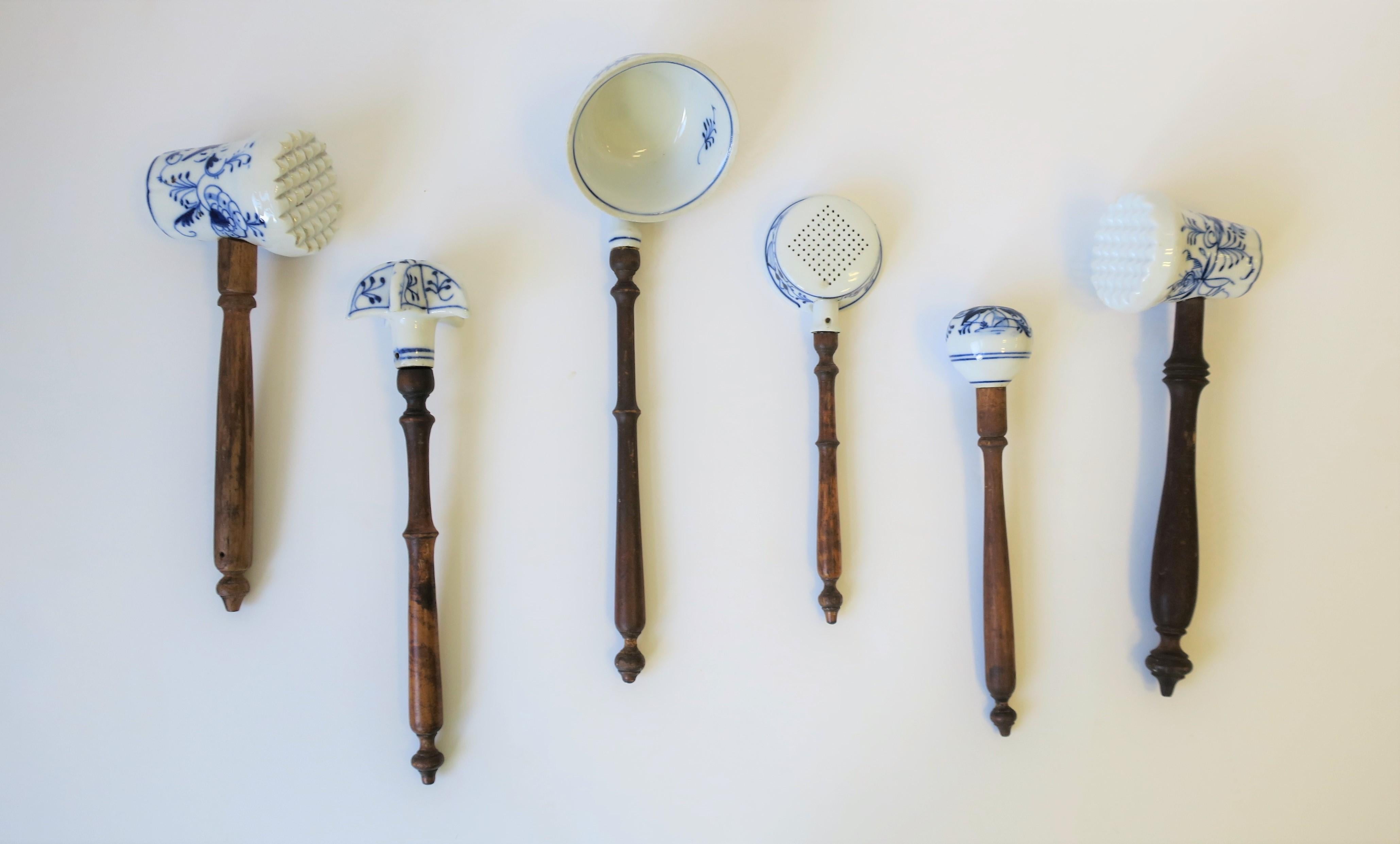 A beautiful antique set of 6 German Meissen blue and white onion pattern porcelain kitchen cooking pieces/utenciles with wood turned handles, circa late 19th century, Germany. 

Each measure, from L to R from image #1: 
1. Mallet/tenderizer: 10.25