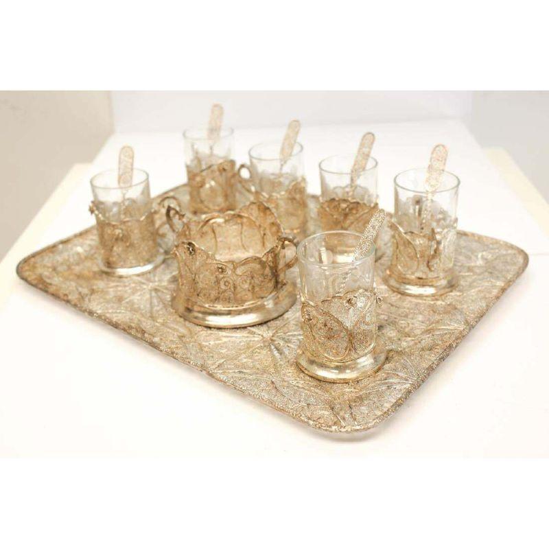 Set of 6 glass tea service & middle eastern sterling silver filigree

A fine and intricate Middle Eastern silver filigree and glass lined tea service for 6. Includes 6 glasses, 6 spoons, a sugar cube bowl and tray. The spoons are original to the