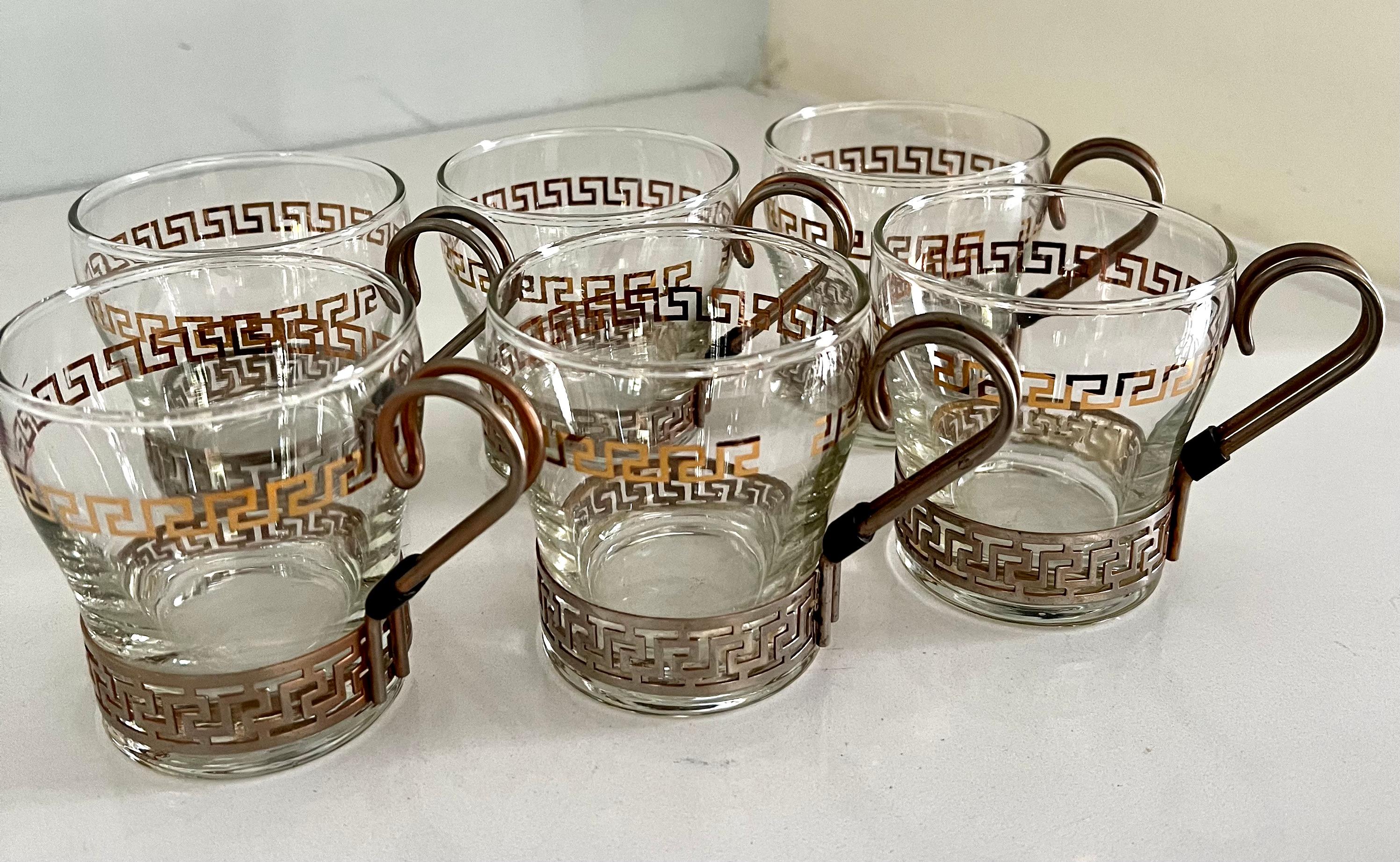 A set of 6 glasses held by a metal framework with handle. The metal has a wonderful greek key framework. A compliment to any bar or cocktail setting for those hot drinks, or for the kitchen for cocoa and marshmallows... sexy enough to sit out. 

 