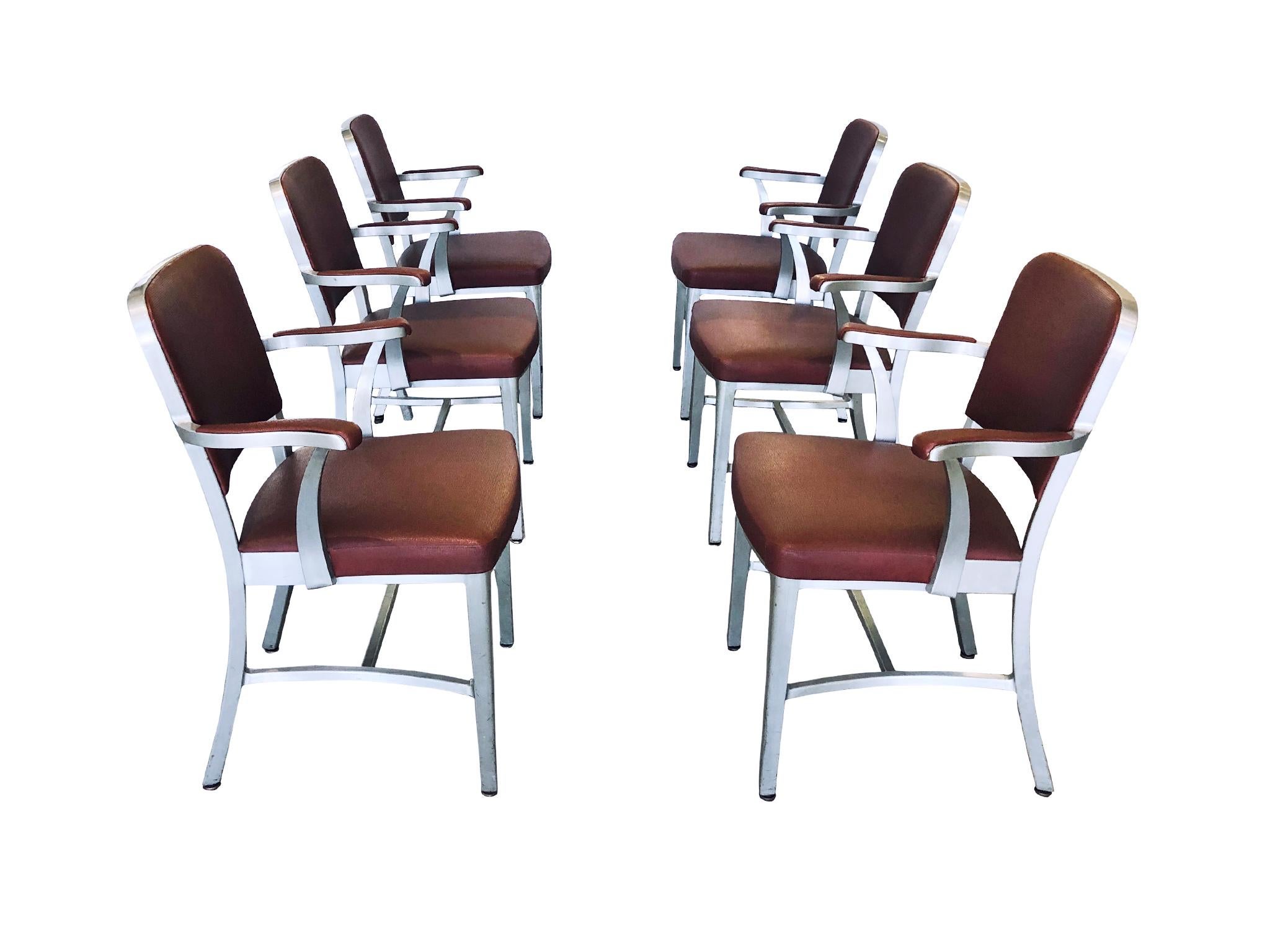 A set of Classic midcentury 6 armchairs manufactured by The General Fireproofing Co. for its line of GoodForm furniture. The chairs are comprised of an aluminum frame and textured vinyl upholstery in maroon. The design of these chairs is simple and