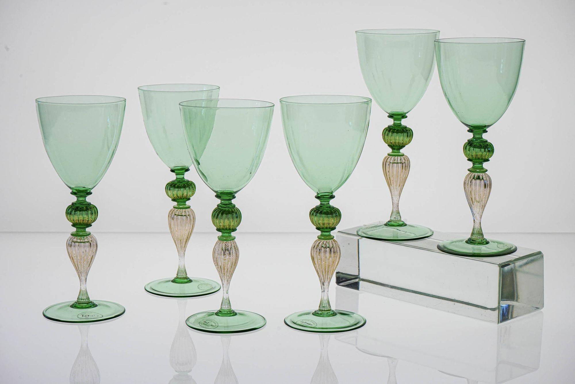 Raro e unico set di 6 bicchieri da vino di Murano fatti a mano di colore verde smeraldo chiaro con applicazione di foglie d'oro sullo stelo.

Lo stelo è composto da 4 sezioni. Due elementi rigati, uno sferico in verde e oro e uno a forma di goccia