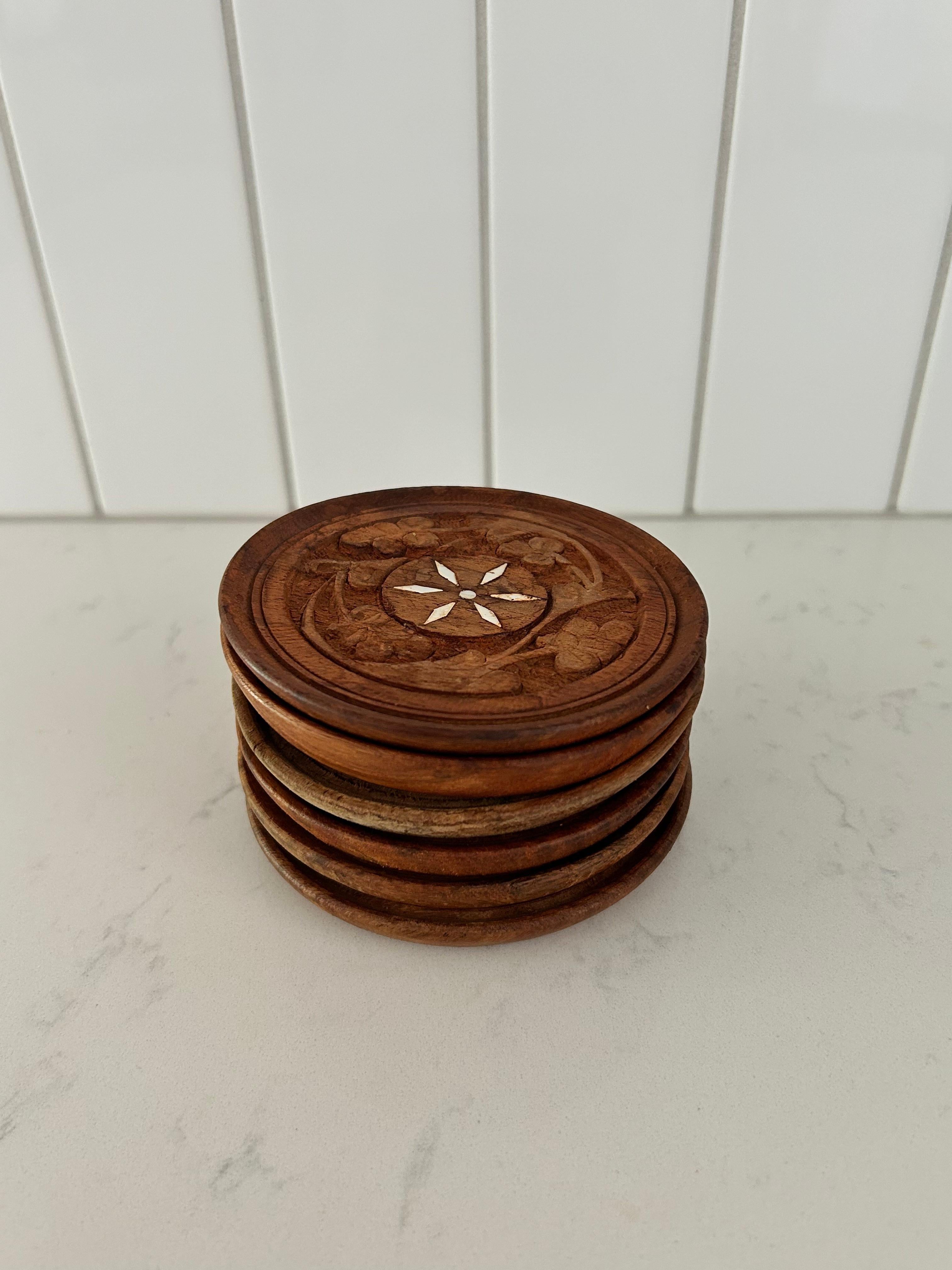 Set of (6) hand made drink coasters that are Made in India with intricate hand carved floral details from the 1970s.  Since these are hand made and hand carved, each coaster is slightly different.  One coaster does have some fading, and a slight