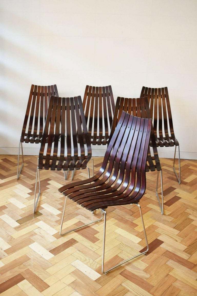 Stunning set of six 1957 high back 'Scandia' dining chairs designed by Hans Brattrud for Hove Møbler.
These gorgeous Norwegian chairs feature broadening backs comprised of laminated wood slats. They are raised by a chromed wire base with hairpin