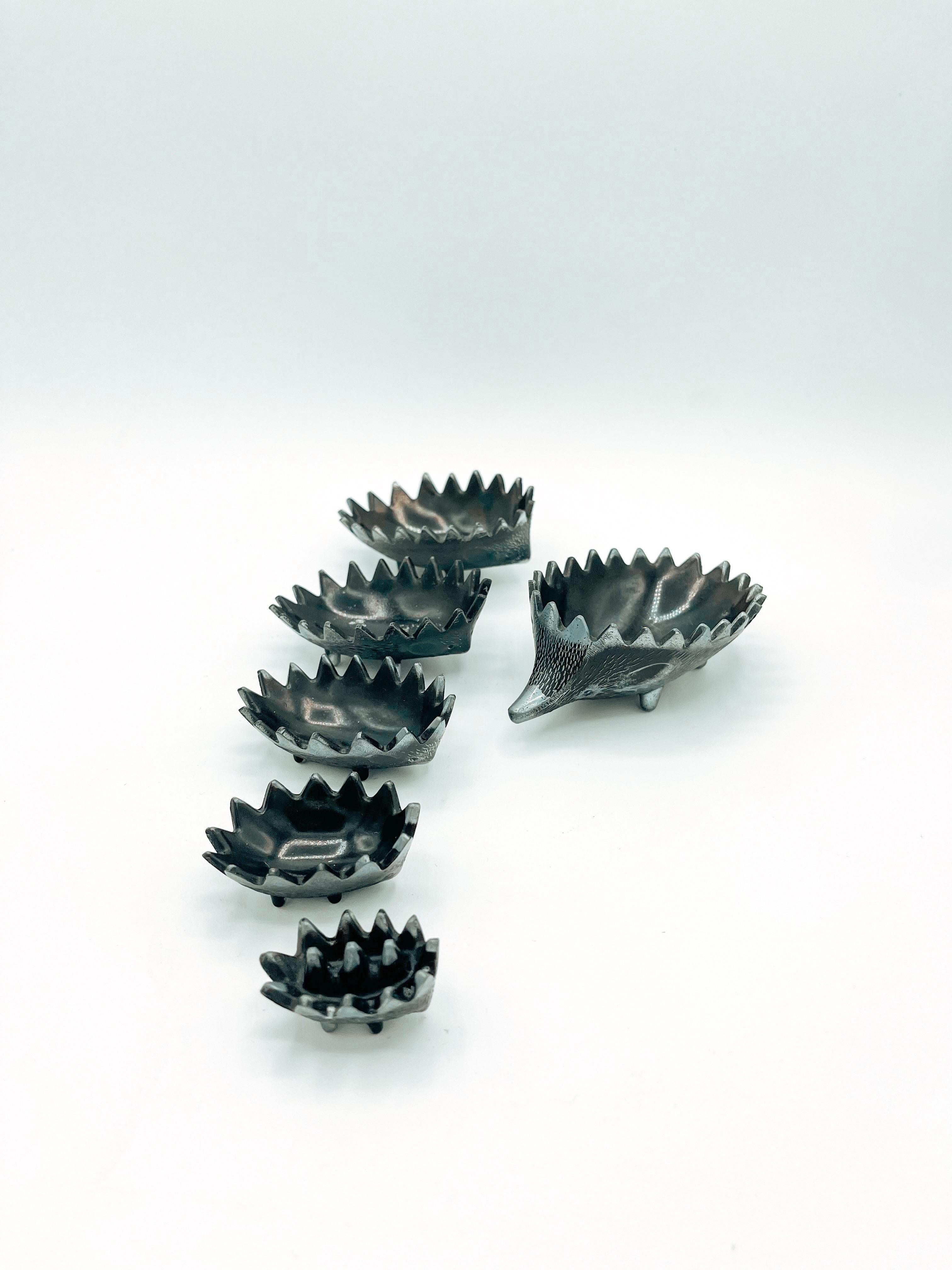 This charming set of 6 stackable hedgehog ashtrays, crafted in the manner of Walter Bosse, perfectly blends functionality with whimsical mid-century design. Made from a dark, durable material, each hedgehog is beautifully detailed and can be used as