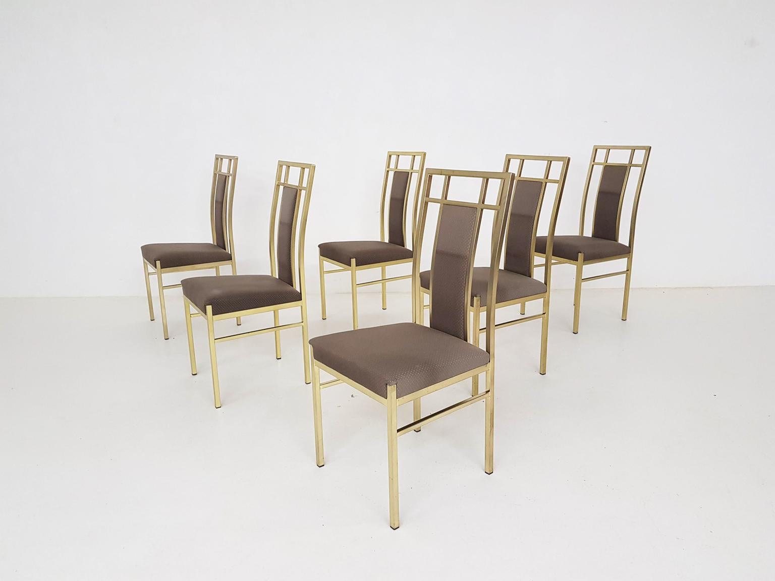 Set of 6 brass colored Hollywood Regency style dining chairs. The fabric is original and has a nice golden pattern, which matches the frame perfectly. The fabric does have some minor stains, but we think it is nicer to keep this original fabric