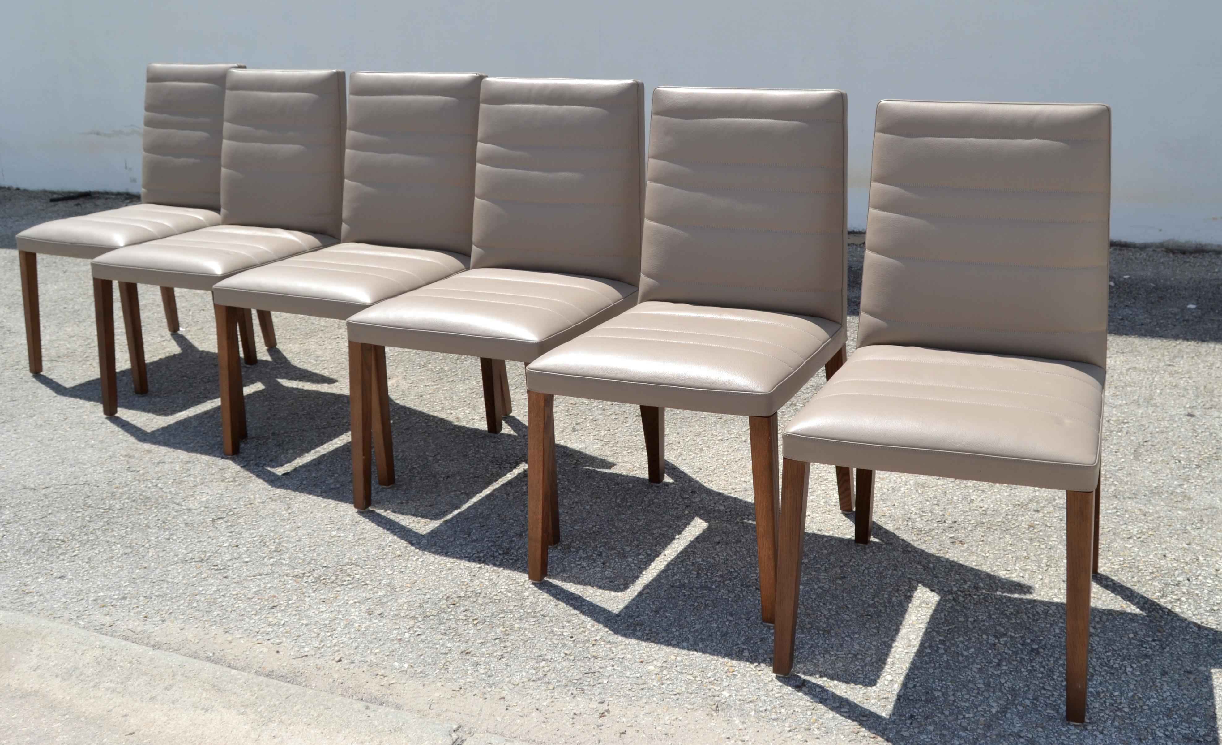 Set of 6 marked Poltrona Frau Vittoria Gray Leather and Wood Legs Dining Chairs.
Made in Italy with exceptional Craftsmanship.
Very heavy and tall Backrest.
The wood is stained in a dark brown Finish.
All Chairs have the Poltrona Frau Logo pressed