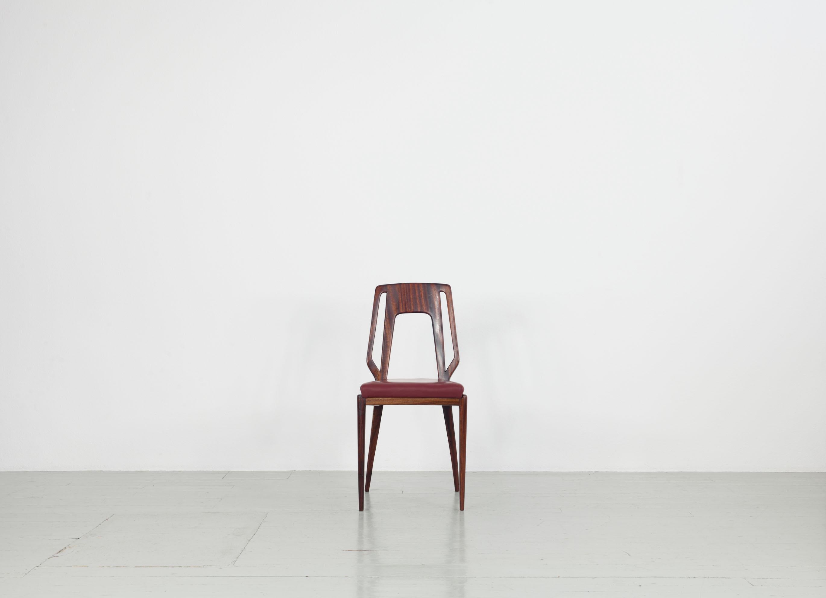 Cet ensemble de six chaises italiennes est fait d'acajou massif brillant et de coussins d'assise recouverts de similicuir rouge foncé d'origine. Les cadres des chaises restaurés et les housses en faux cuir ne présentent aucune imperfection. Une