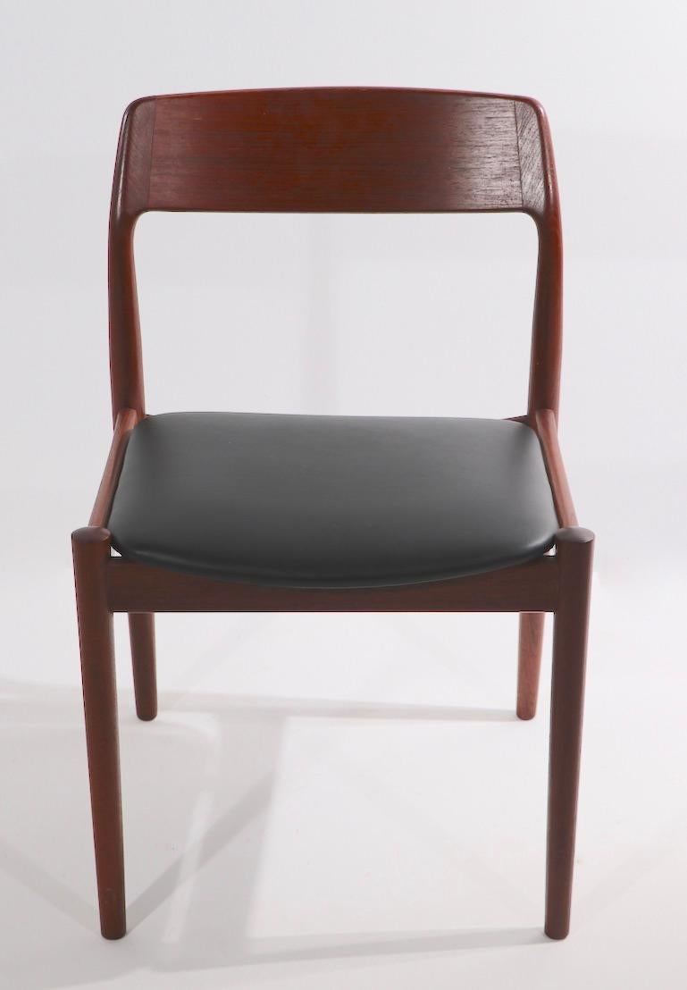 Classic Danish modern set of dining chairs designed by Nelis Moller for JL Moller ( model 75 ). This set is in excellent original condition, clean and ready to use. The chairs have solid teak frames, and black vinyl seats, included in this set are 4