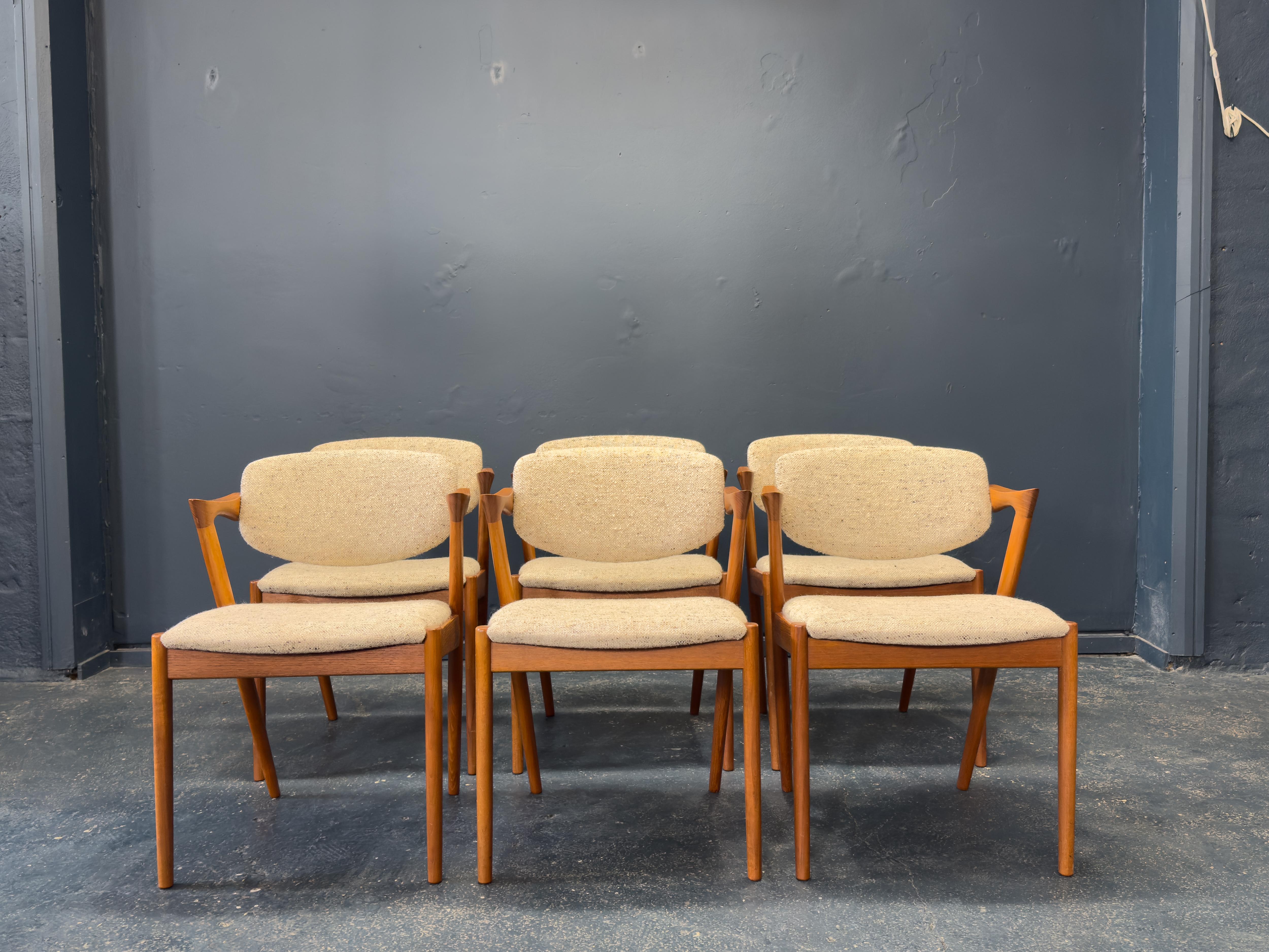 Questo eccezionale set di sei sedie da pranzo Model 42 di Kai Kristiansen è un ottimo esempio di design danese della metà del secolo scorso al massimo della sua raffinatezza. Realizzate in teak dai toni intensi, queste sedie sono famose per le loro