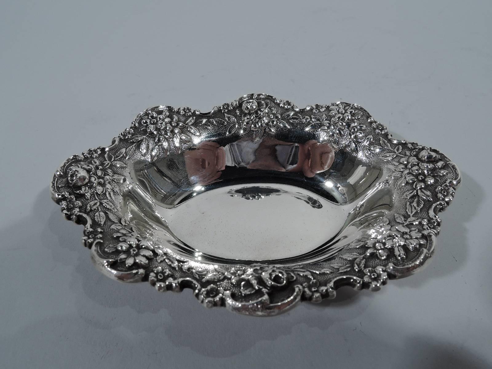 Set of six sterling silver nut dishes. Made by S. Kirk & Son in Baltimore. Each: Plain oval well and tapering sides. Scrolled scalloped rim with repousse floral garland on stippled ground. Hallmark (1932-61) includes no. 142. Total weight: 10 troy