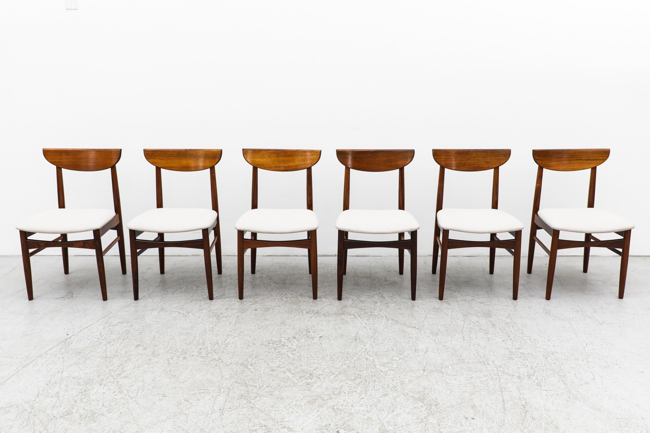 Set of 6 rosewood dining chairs with half moon shaped backrests and newer bone white upholstered seats. Designed by Danish designer Kurt Østervig. In original condition with a few visible scratches on the frames. Wear is consistent with their age