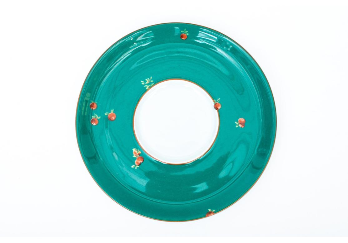 A set of six Lafarge Limoges for Le Cirque cups with saucers. The cups displaying orange borders with imagery of monkeys with fruit and dark green trim. The saucers are dark green with fruits and orange trim. Made in France. Can be used as a small