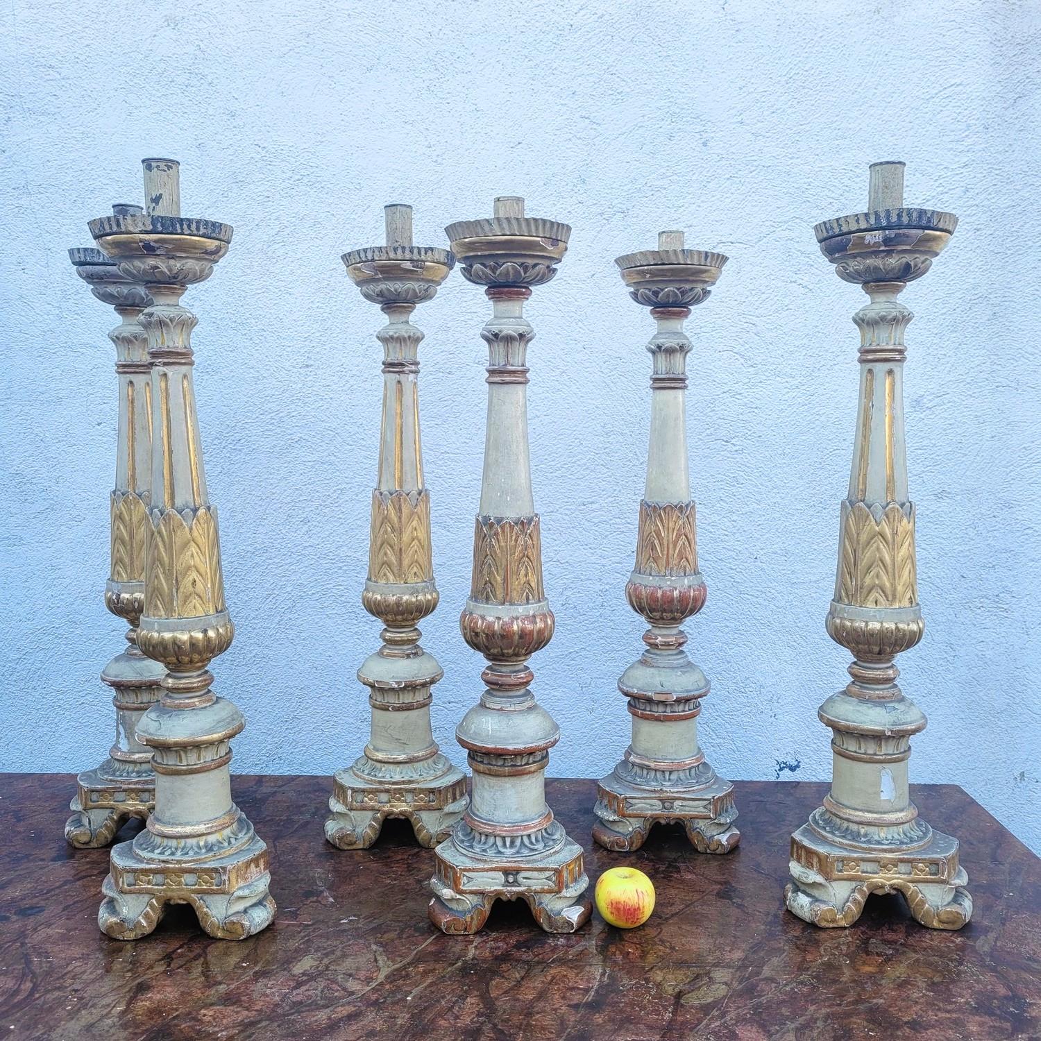 Rare ensemble de six grands chandeliers ou candélabres, sculptés dans du bois laqué crème et doré.   

Posés au sol ou sur les autels des églises ou des chapelles privées, qu'ils ont illuminées et décorées, ces candélabres ne sont peints que sur la