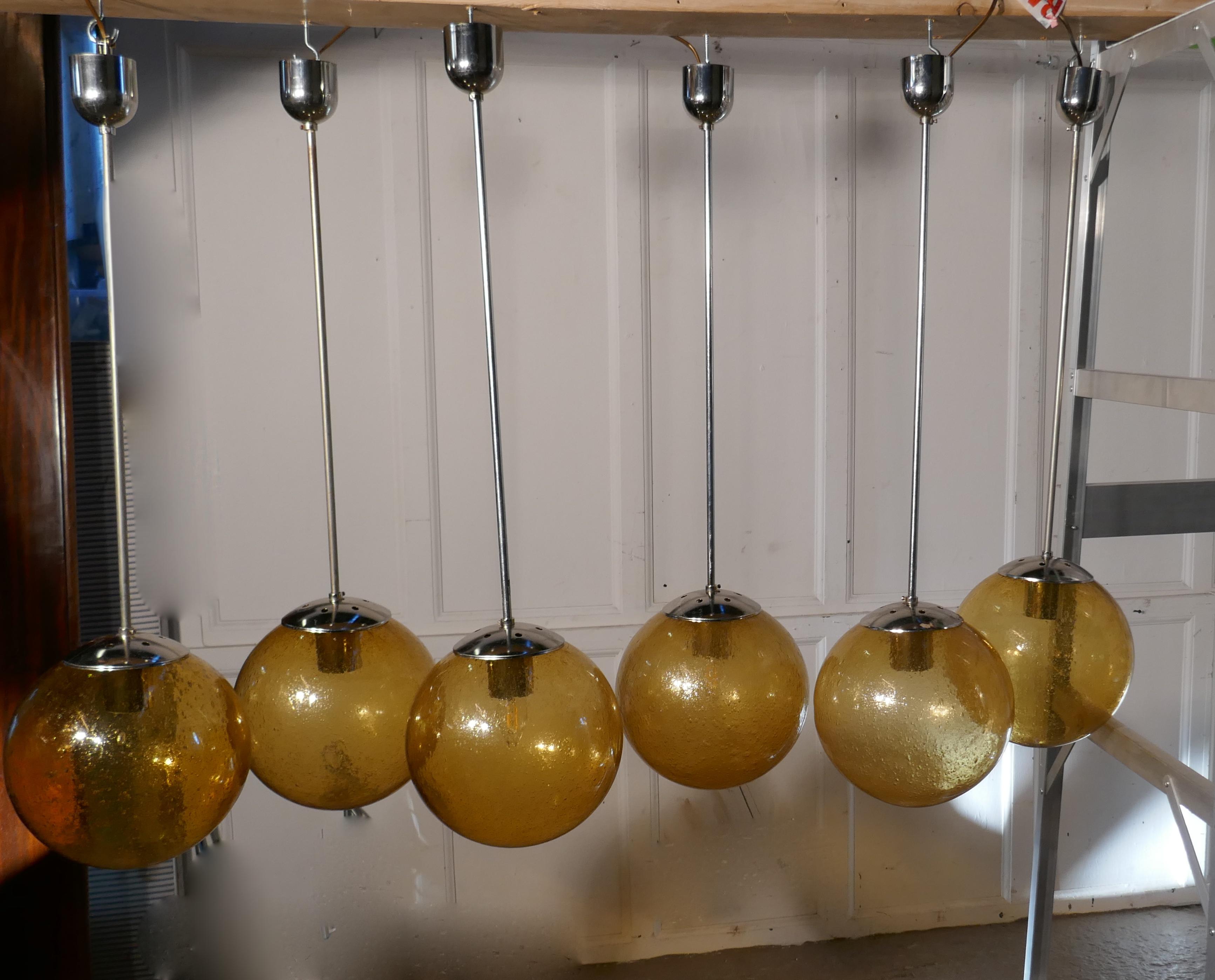Set of 6 large retro amber globe and chrome lights.

I rare find, these lights have been used but they are in close to original condition, the original amber glass raindrop globe shades even have their original cardboard cartons
The globes are