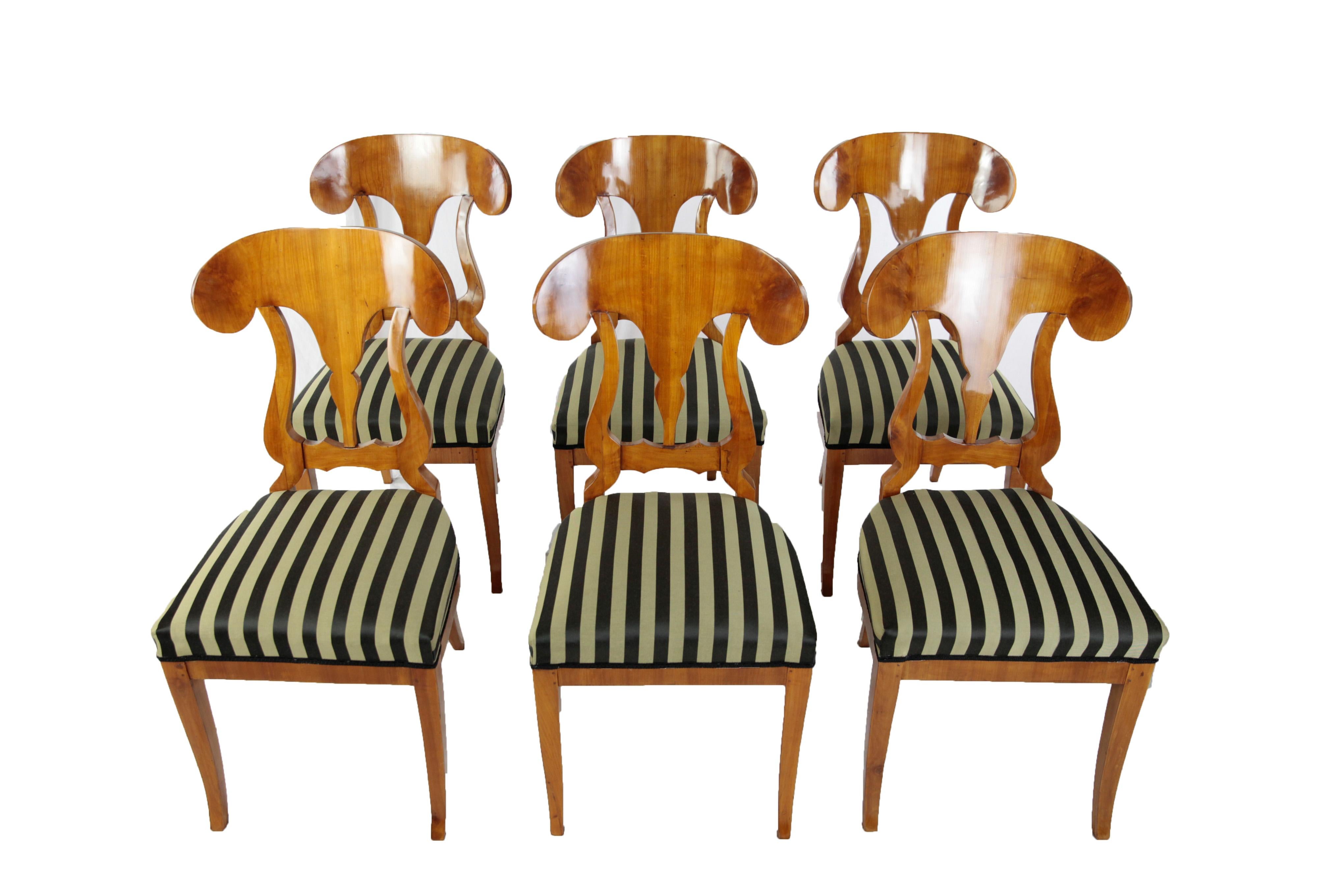 Set of 6 chairs made of cherrywood veneered, made circa 1850-1860 in Germany. The legs of the chairs are slightly concave. The seat of the chairs was newly upholstered and covered with a striped cotton-mix fabric. The backrests are moving in shape