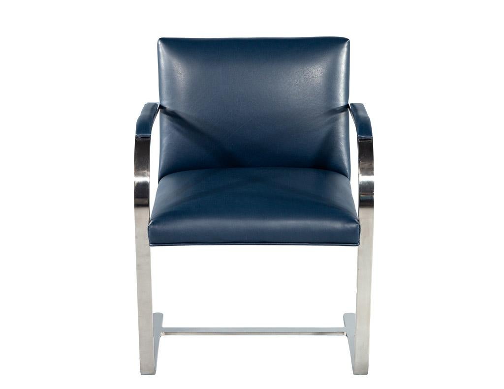 This set of 6 leather Brno dining arm chairs, vintage circa 1970s, has been completely restored with all new Italian leather in a deep indigo color tone. The polished stainless steel curved frames and upholstered armrests give the chairs a