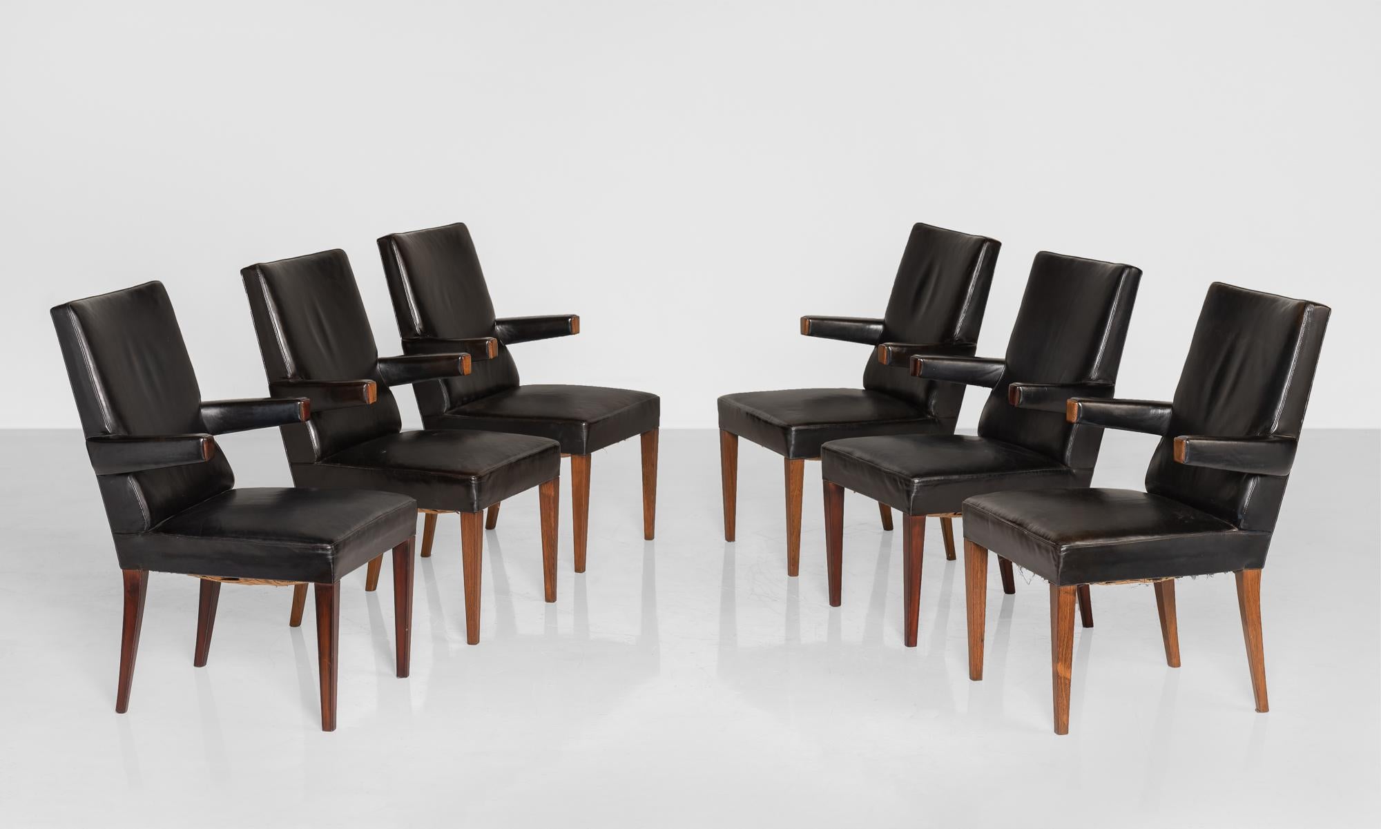 Set of (6) leather dining chairs, England, circa 1960.

Rosewood legs and arms with original leather upholstery.
 