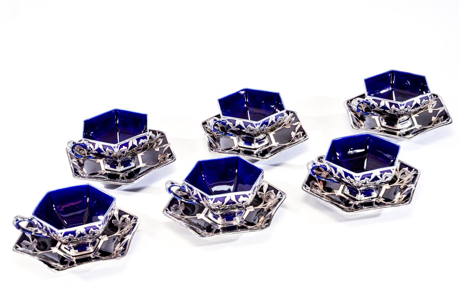 Questo set di 6 tazze e piattini esagonali di rara forma è stato realizzato dalla Lenox's Ceramic Art Company, tra il 1887 e il 1900 circa, che in seguito divenne Lenox. Sono abbondantemente decorati con un'elegante sovrapposizione in argento