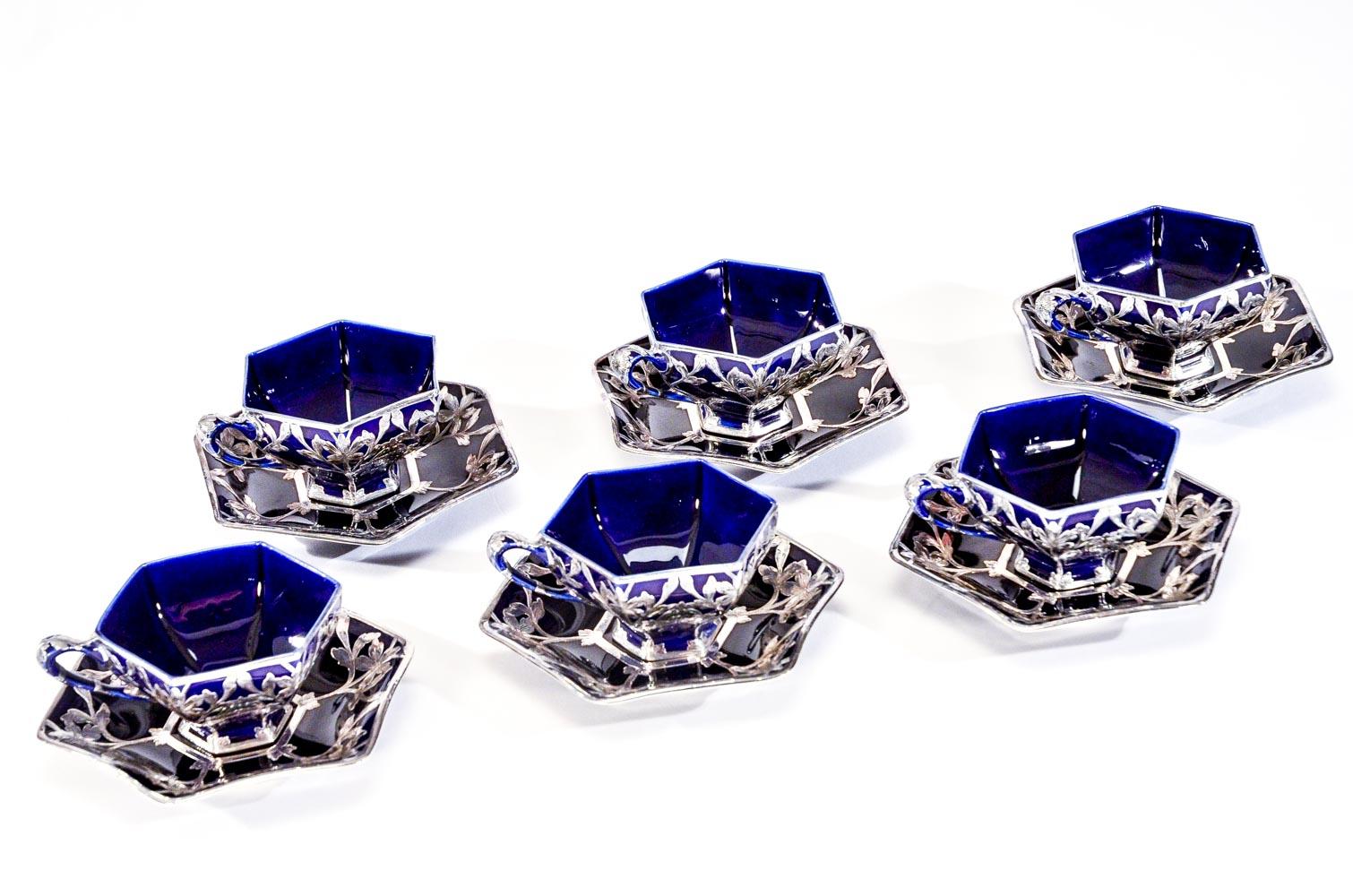 This set of 6 rare shaped hexagonal cups and saucers are made by the Ceramic Art Company, ca. 1887-1900 which later became Lenox. They are profusely decorated with elegant Art Nouveau sterling silver overlay with geometrically placed flowers which