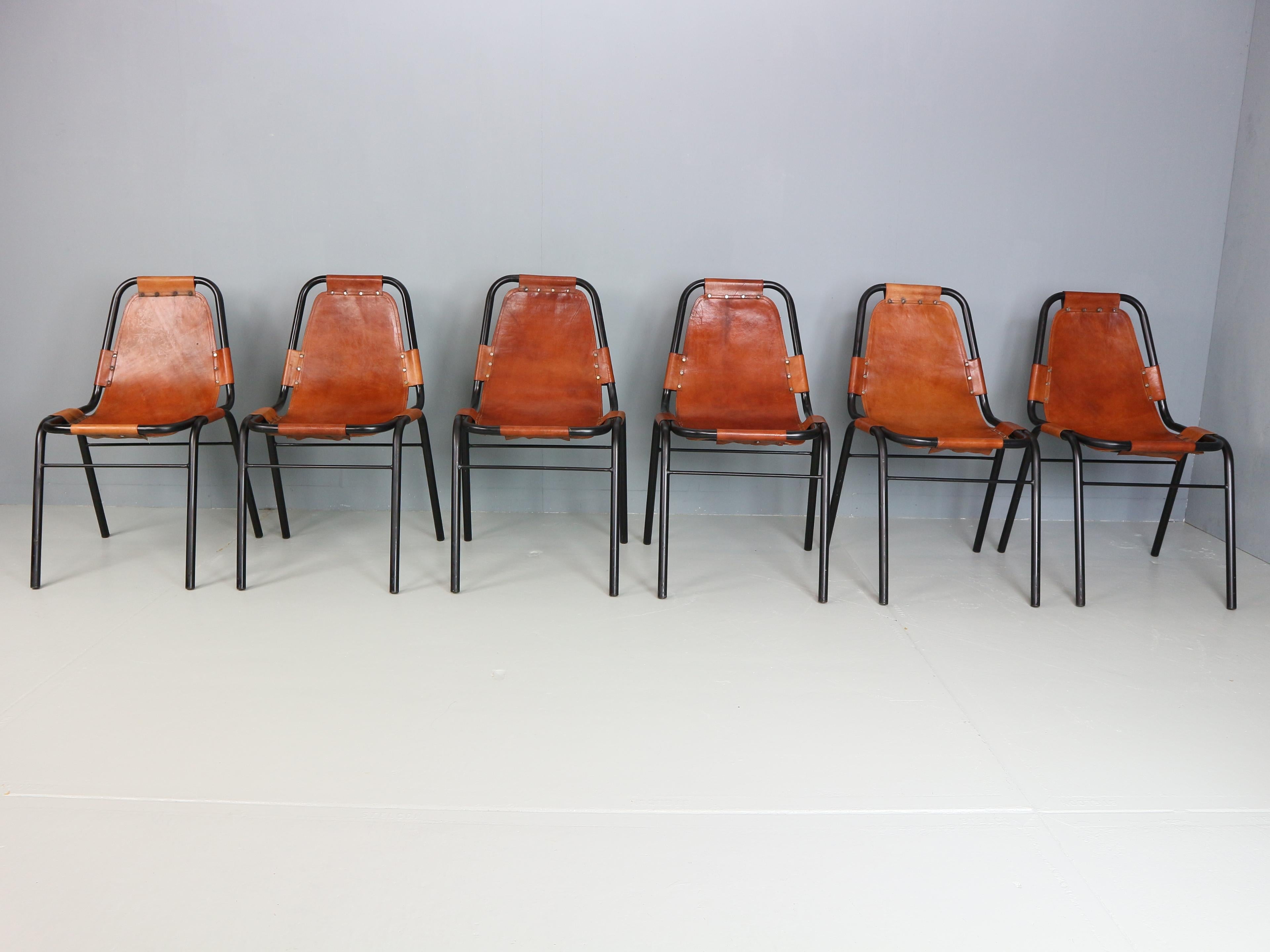 Set di 6 sedie Les Arcs con struttura tubolare in metallo laccato nero e sedute in pelle color cognac. Sedie nello stile di Dal Vera e selezionate da Charlotte Perriand (1903-1999) per Les Arcs, una stazione sciistica nelle Alpi nel sud-est della