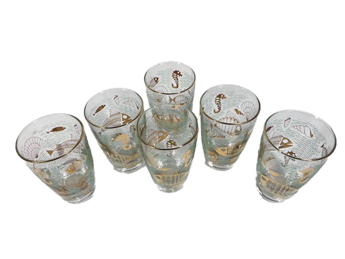 Six Libbey glass tumblers of tapered form with slightly bowed-out sides with stylized marine life in 22k gold surrounded by 'waves' of raised translucent green enamel.