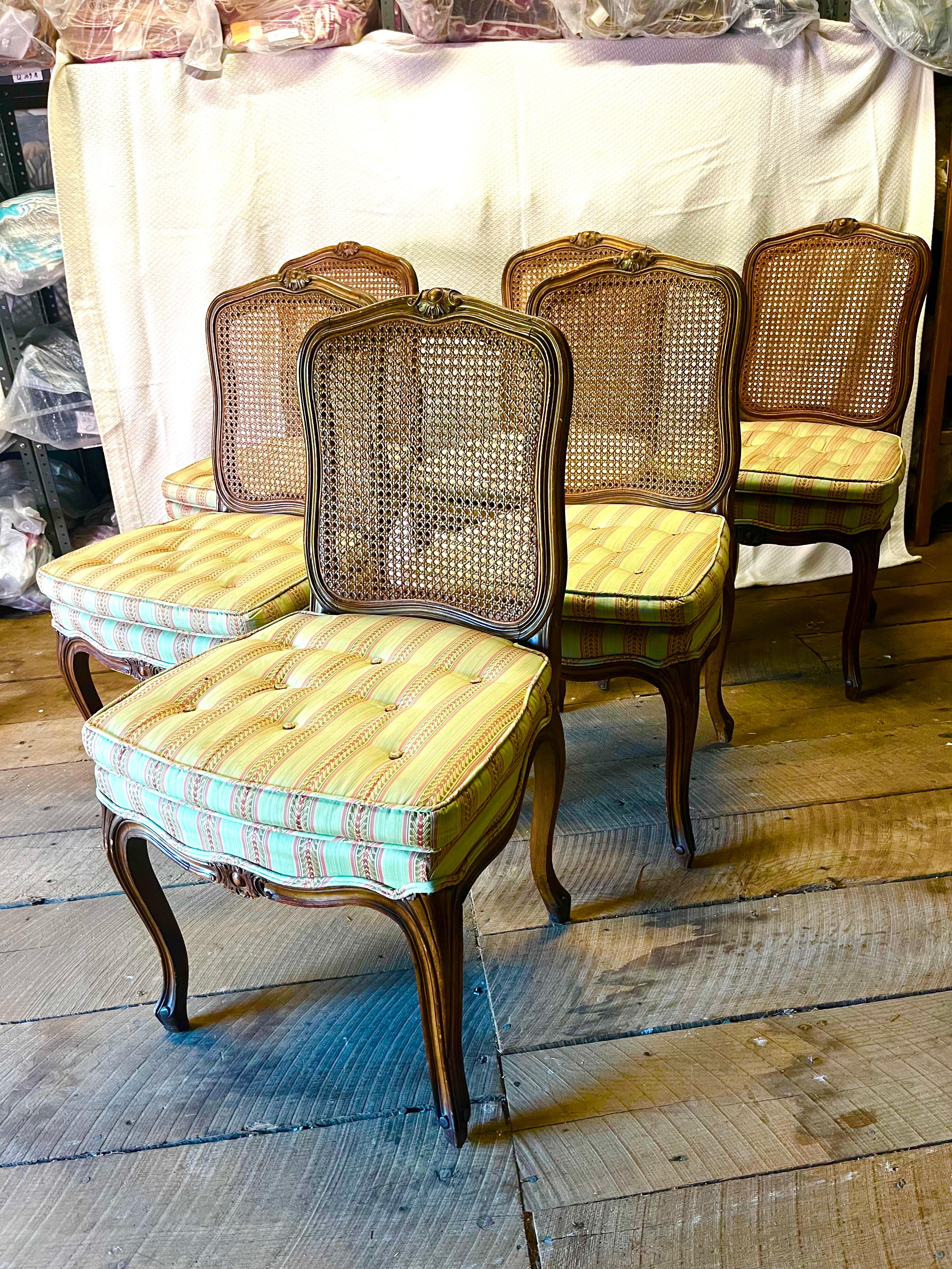 Un set di 6 sedie da pranzo in stile Louis XV con schienali a canne e sedili imbottiti, circa 1900. Le sedie sono in faggio con finitura in noce e sono ben intagliate sullo schienale e sulla seduta. Il tessuto dovrà essere cambiato perché macchiato
