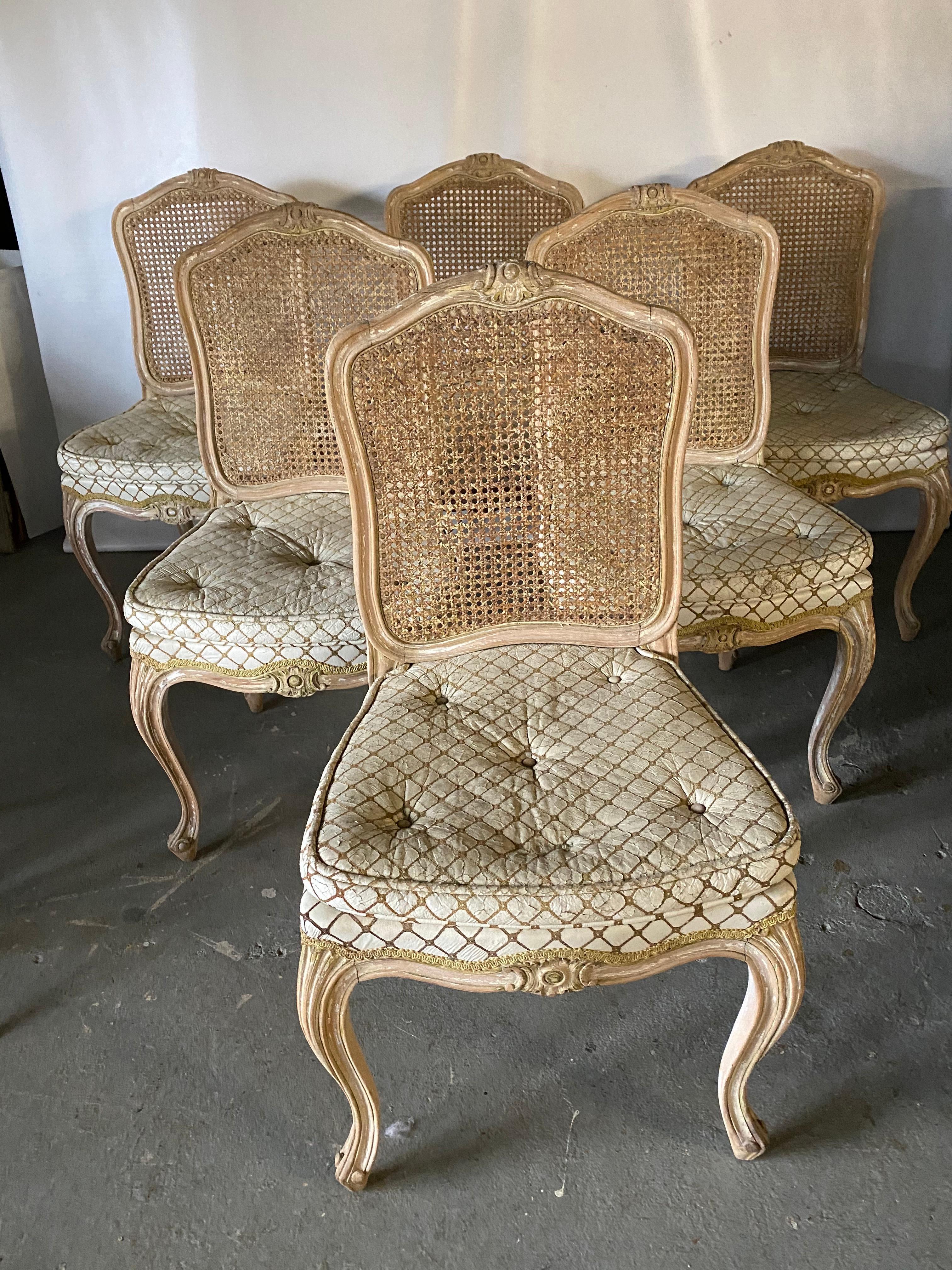 Set of 6 antique French Louis XV Provincial style painted dining chairs, upholstered seats with caned backs. Paint has mostly been lost but leaving it with great rustic country charm that is hard to duplicate. Chairs have carved crest detail on seat