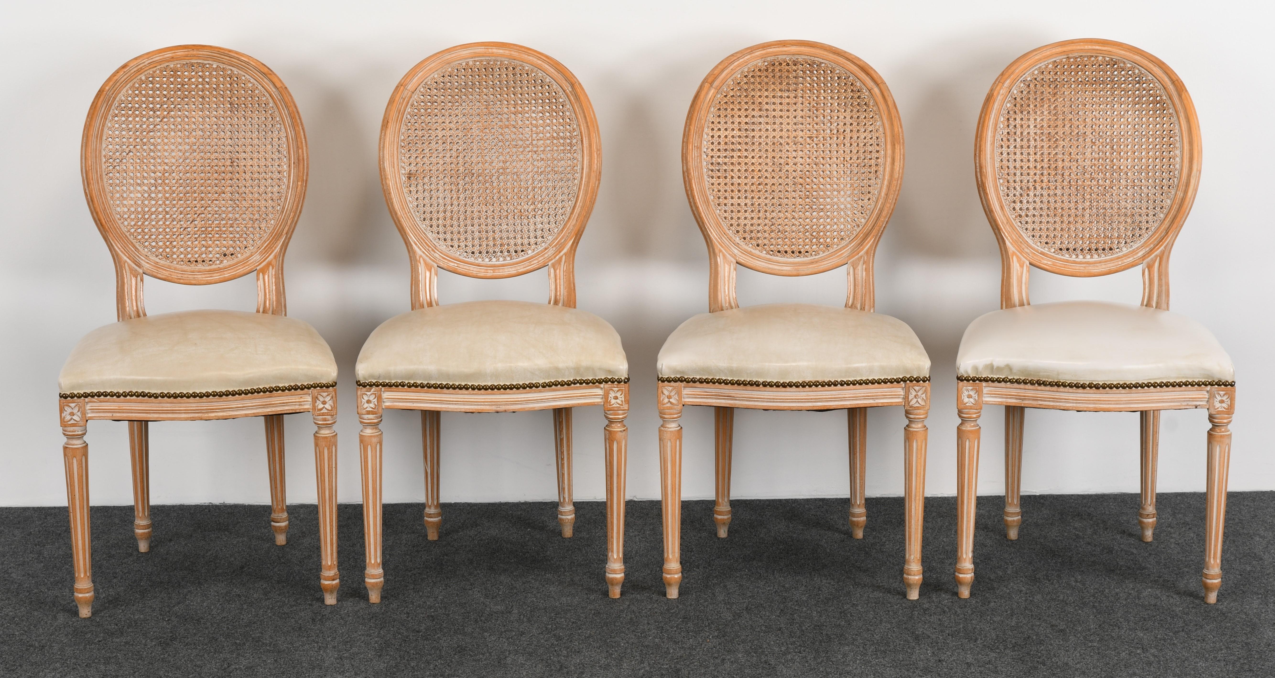 A decorative set of 6 French Louis XVI style solid beech wood dining chairs with oval and cane backs. There are four side chairs and two armchairs. New upholstery is necessary. Chairs are structurally sound, very good vintage condition with