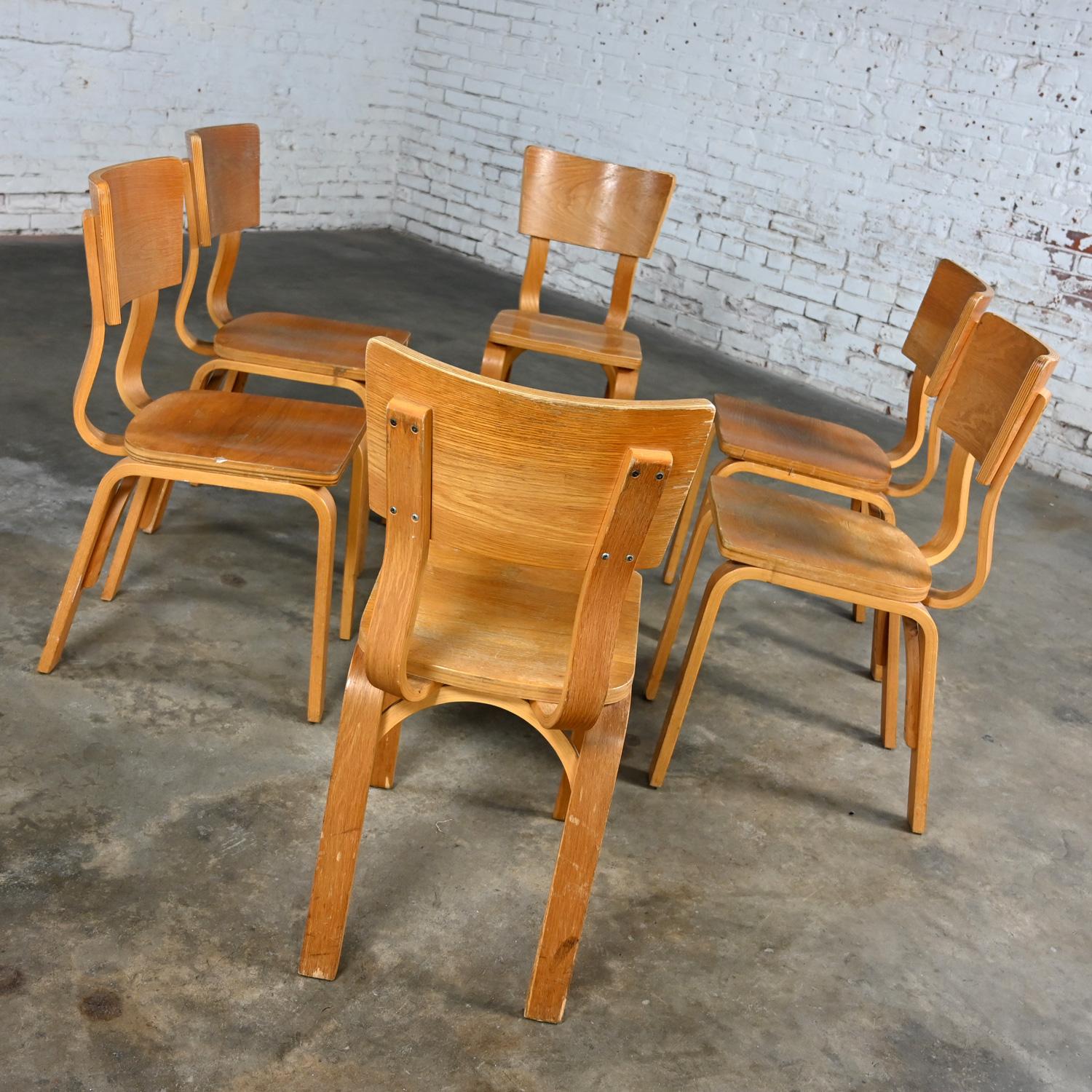 Marvelous vintage Mid-Century Modern Thonet #1216-S17-B1 dining chairs comprised of bent oak plywood with saddle seats and a single bow back stretcher, set of 6, as is condition. Beautiful condition, keeping in mind that these are vintage and not
