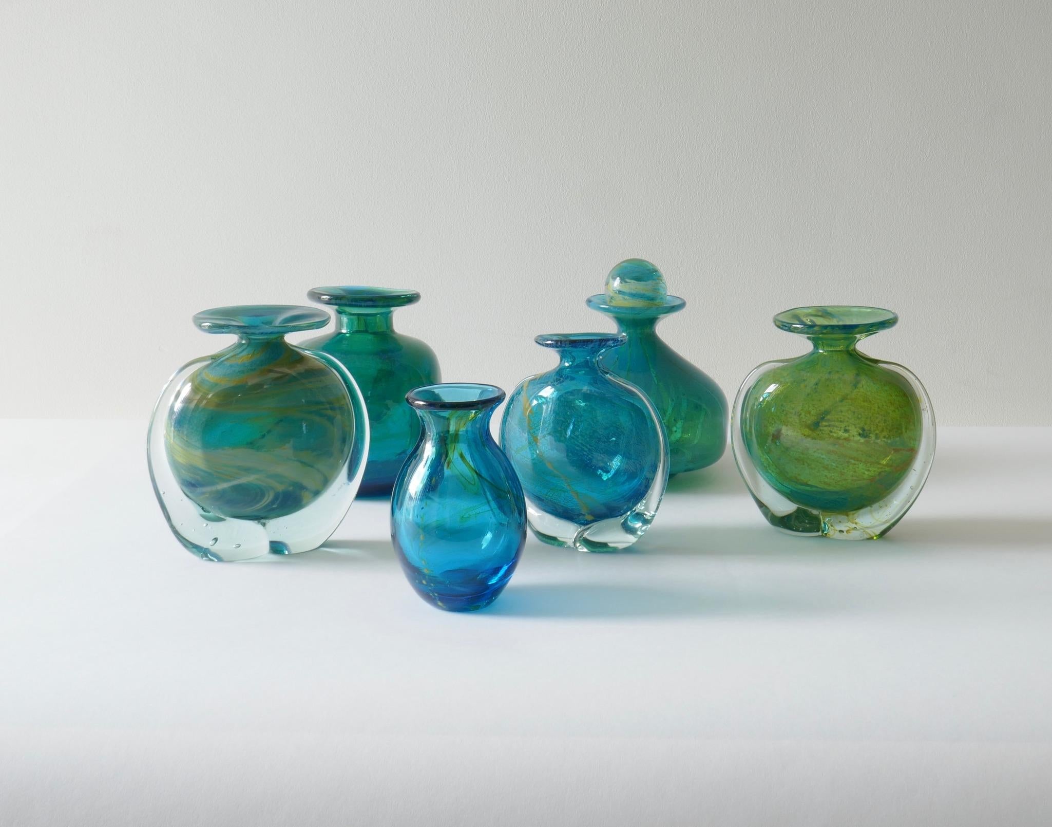 Set of 6 Mdina turquoise blue and green glass vases, 1960s. 
Dimensions from left to right :
H 15 cm, D 13cm 
H 14.5 cm, W 15cm, D 5cm, signed 
H 17 cm, 14cm, signed
H 14cm, W 13cm, D 5cm
H 13cm, W 12cm, D 5cm, signed
H12cm, D 7cm.
 