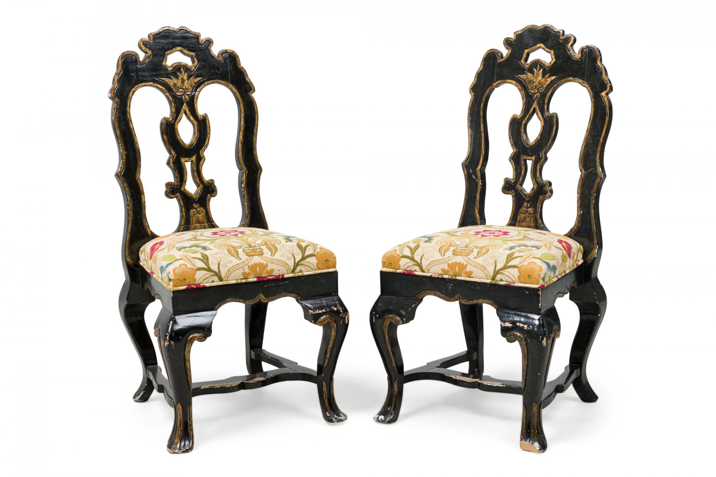 Set of 6 Portuguese Rococo Style (20th Century) black giltwood dining / side chairs featuring a shaped frame with flattened openwork back, carved splat, padded seat upholstered in a gold monotone patterned fabric accented by blue and red woven