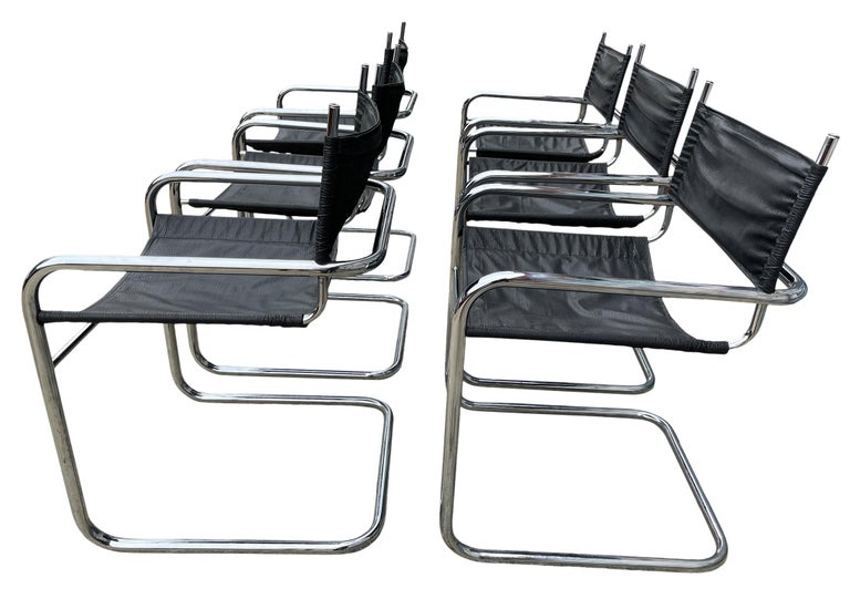 Set of matching 6 mid century cantilevered dining arm chairs In the style of Mart Stam chrome and faux black leather. All original mid century chrome seamless cantilever frames. All original hardware. Ready for immediate use. Located in Brooklyn
