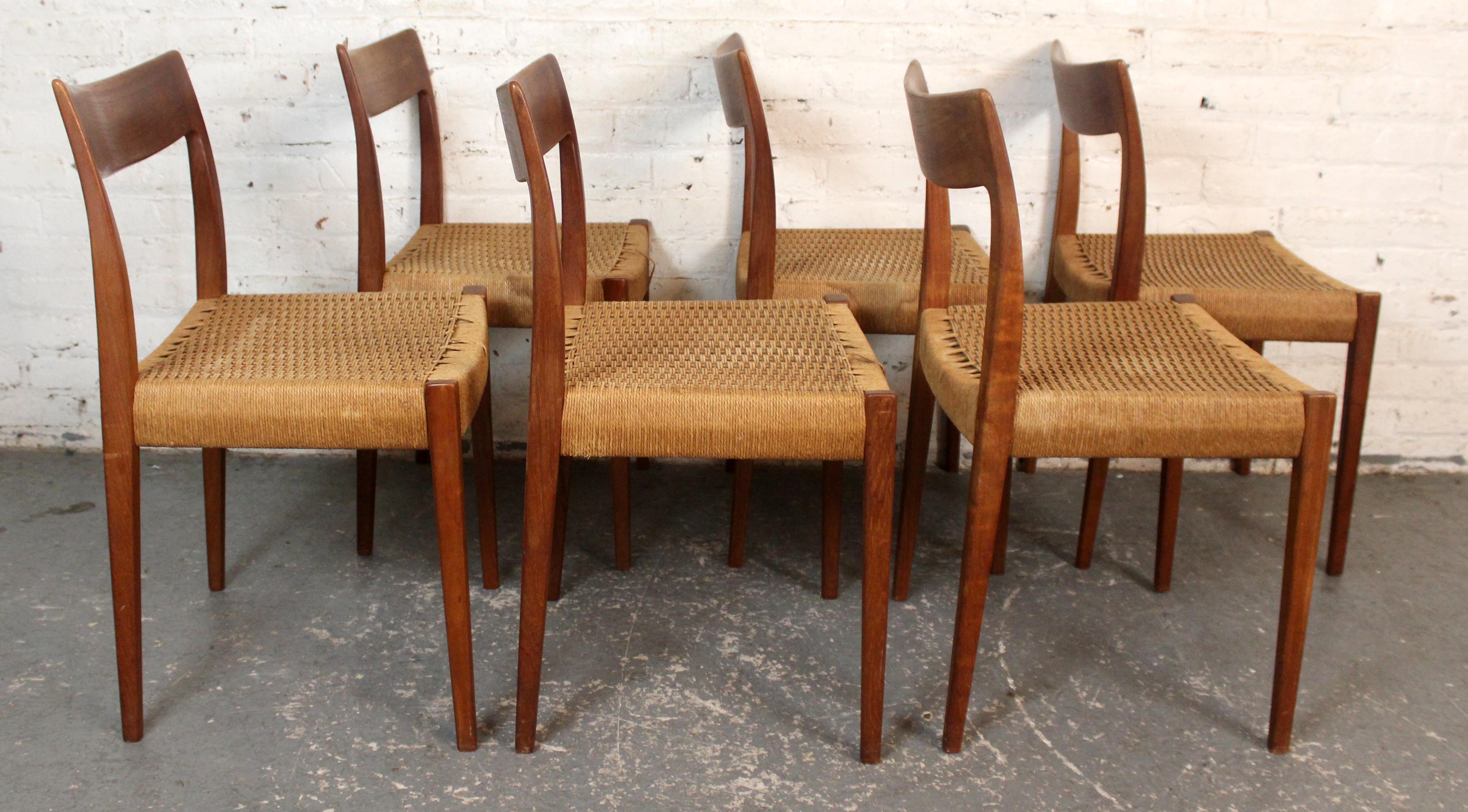 A classic set of six vintage dining chairs featuring solid teak frames and handwoven seats. The clean, minimalist lines and gently tapered legs exemplify the timeless elegance of mid-century design. The Danish papercord seats provide an organic