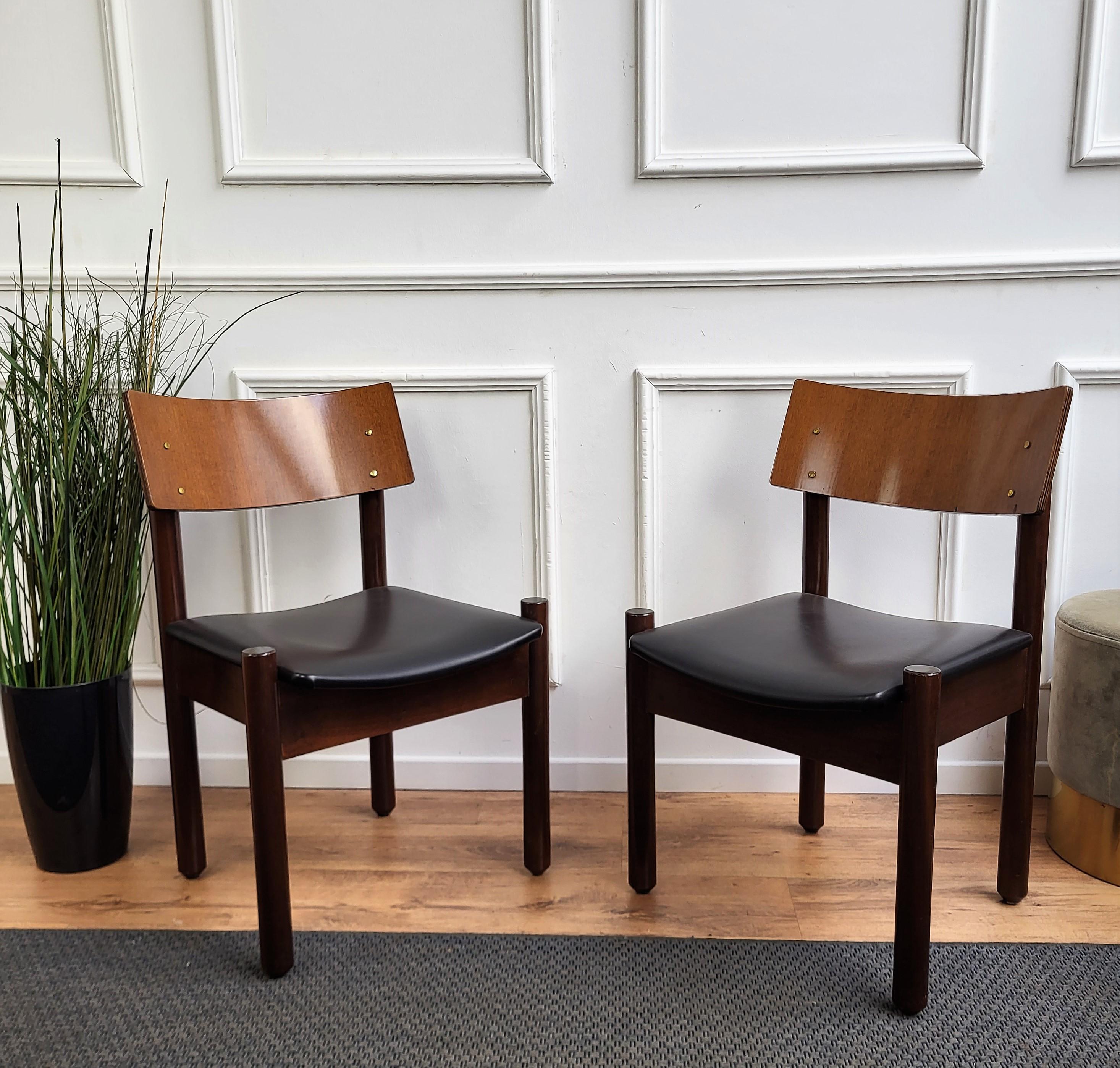 Schönes und stilvolles italienisches Mid-Century Modern Set von 6 Esszimmerstühlen, mit stark gearbeiteter und geformter Holzstruktur und schwarz gepolstertem Sitz. Das einzigartige und typische Design mit der klaren geometrischen Form und dem Dekor