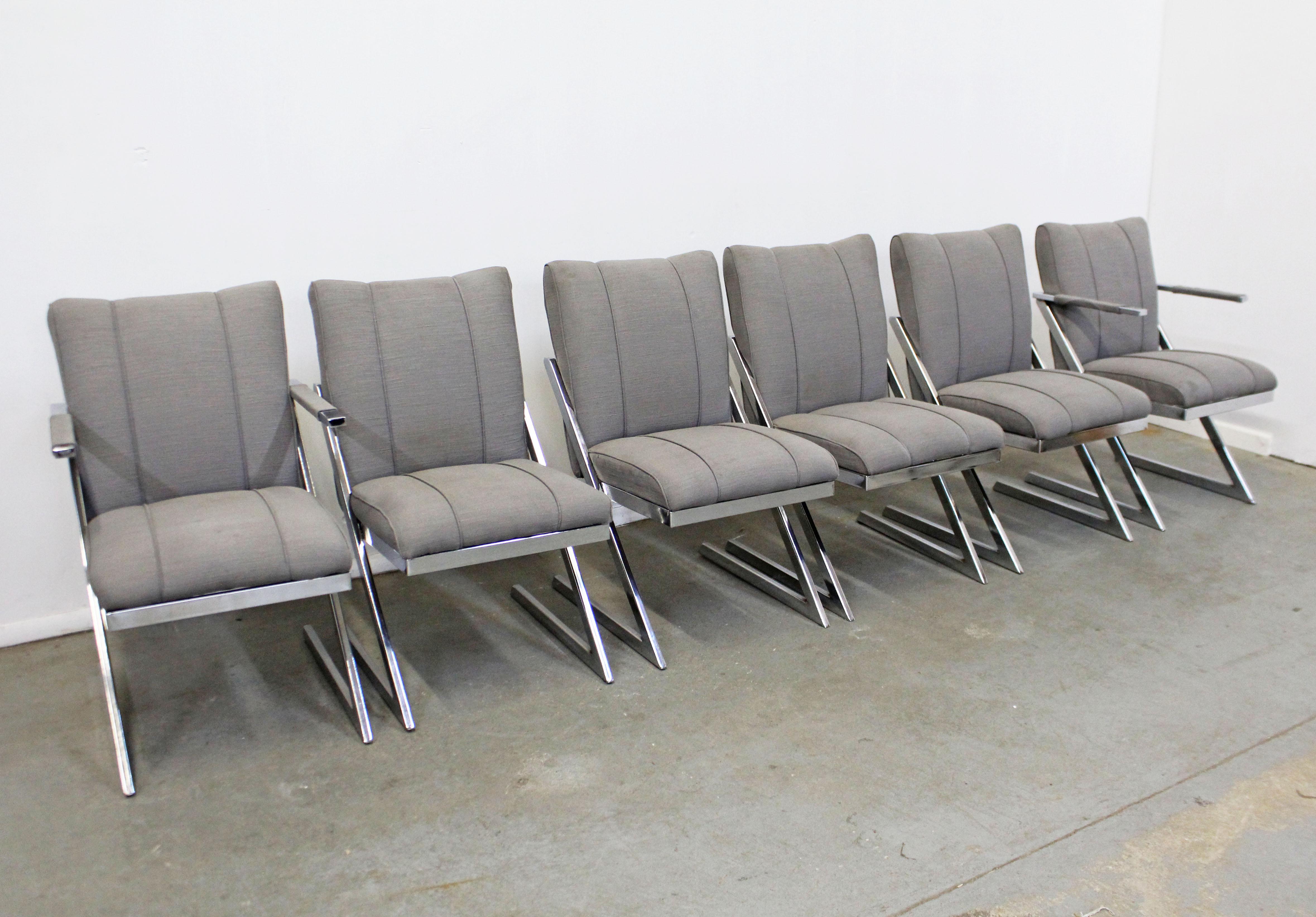 Offered is a set of 6 vintage chrome dining chairs in the style of Milo Baughman. The chairs have a Z-bar cantilevered base made of chrome with gray upholstery. They are in structurally sound condition, need to be reupholstered. Shows some surface