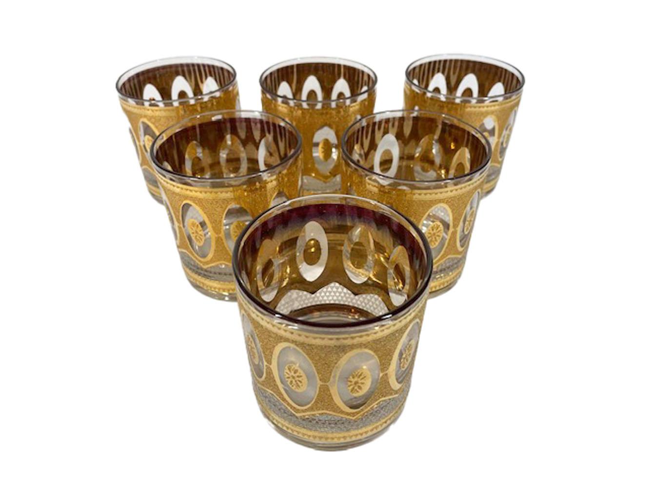 Set of 6 mid-century modern rocks glasses in the Regency pattern by Culver, LTD. decorated in 22k gold with textured and smooth finishes framing a series of oval reserves.