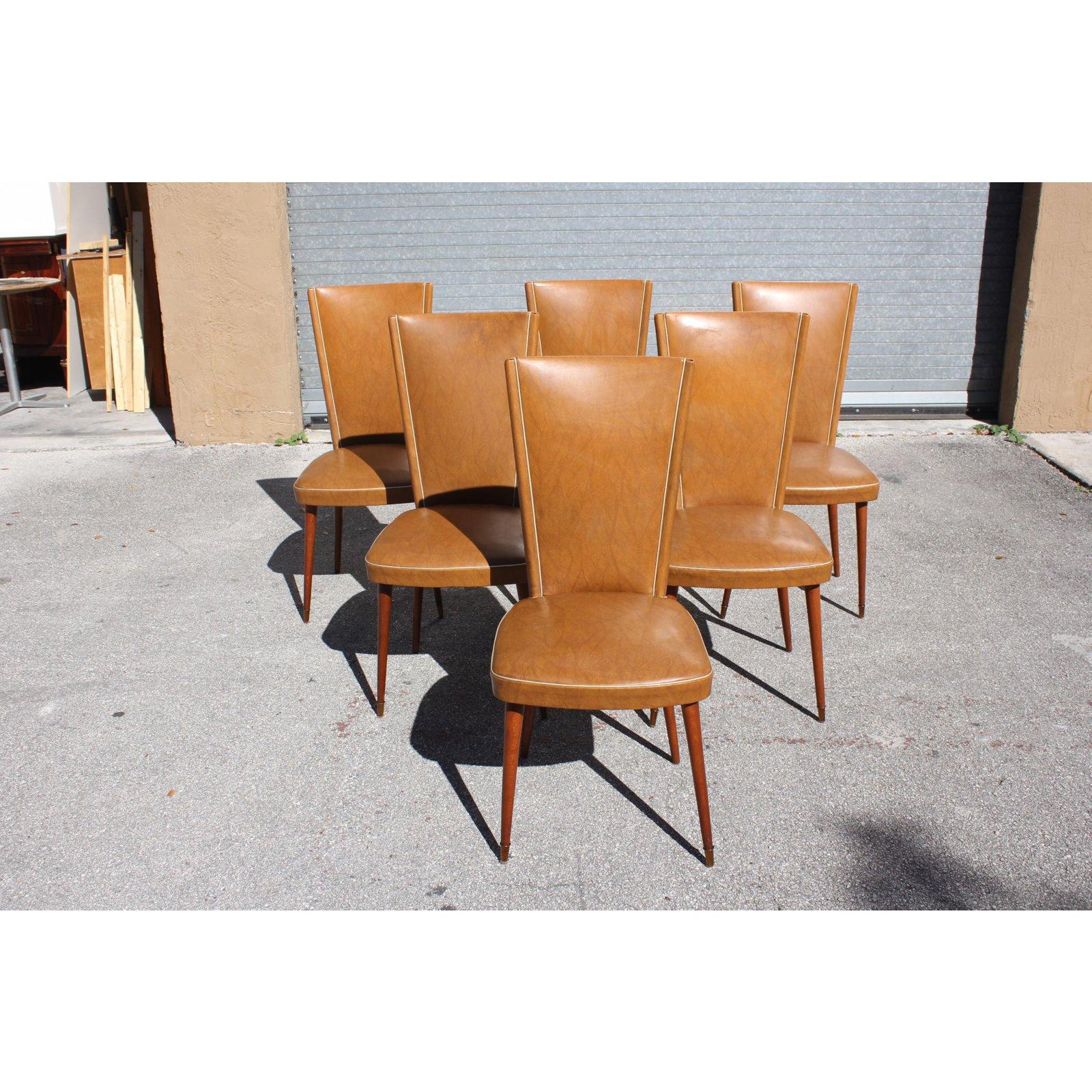 Set of six French Art Deco dining chairs solid mahogany, the two front feet are capped with brass. The chair frames are in very good condition. The reupholstery is vinyl recommended to be change for all 6 dining chairs but the color of the dining