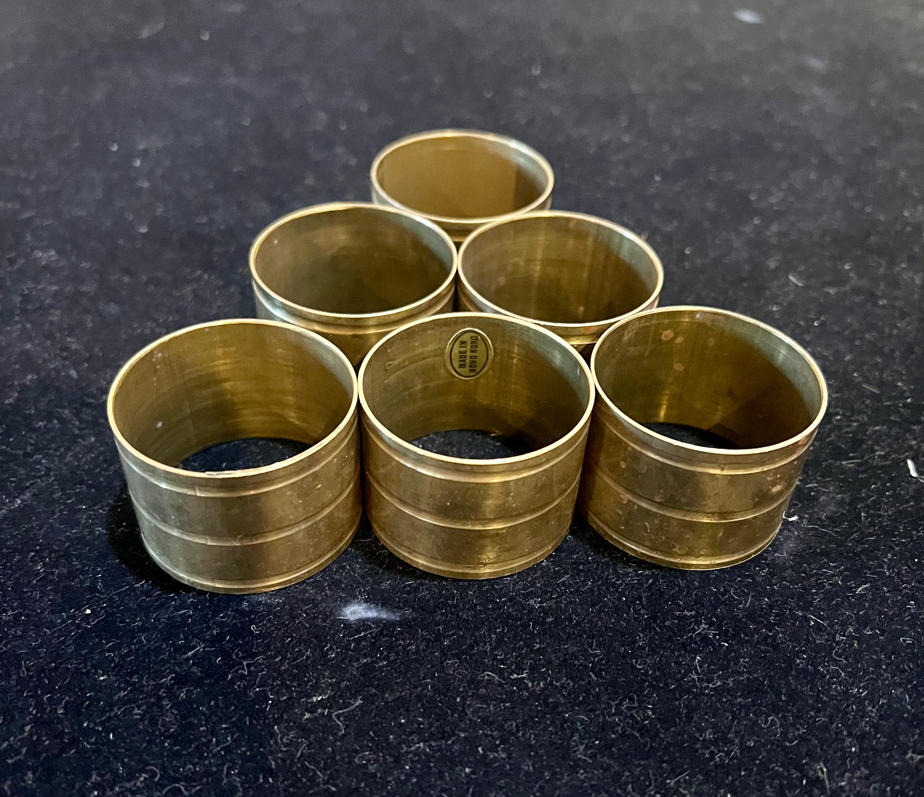  elegante Conjunto de ocho servilleteros de latón MCM, hacia la década de 1970. Los anillos tienen un diseño circular con un bonito acabado de latón patinado.