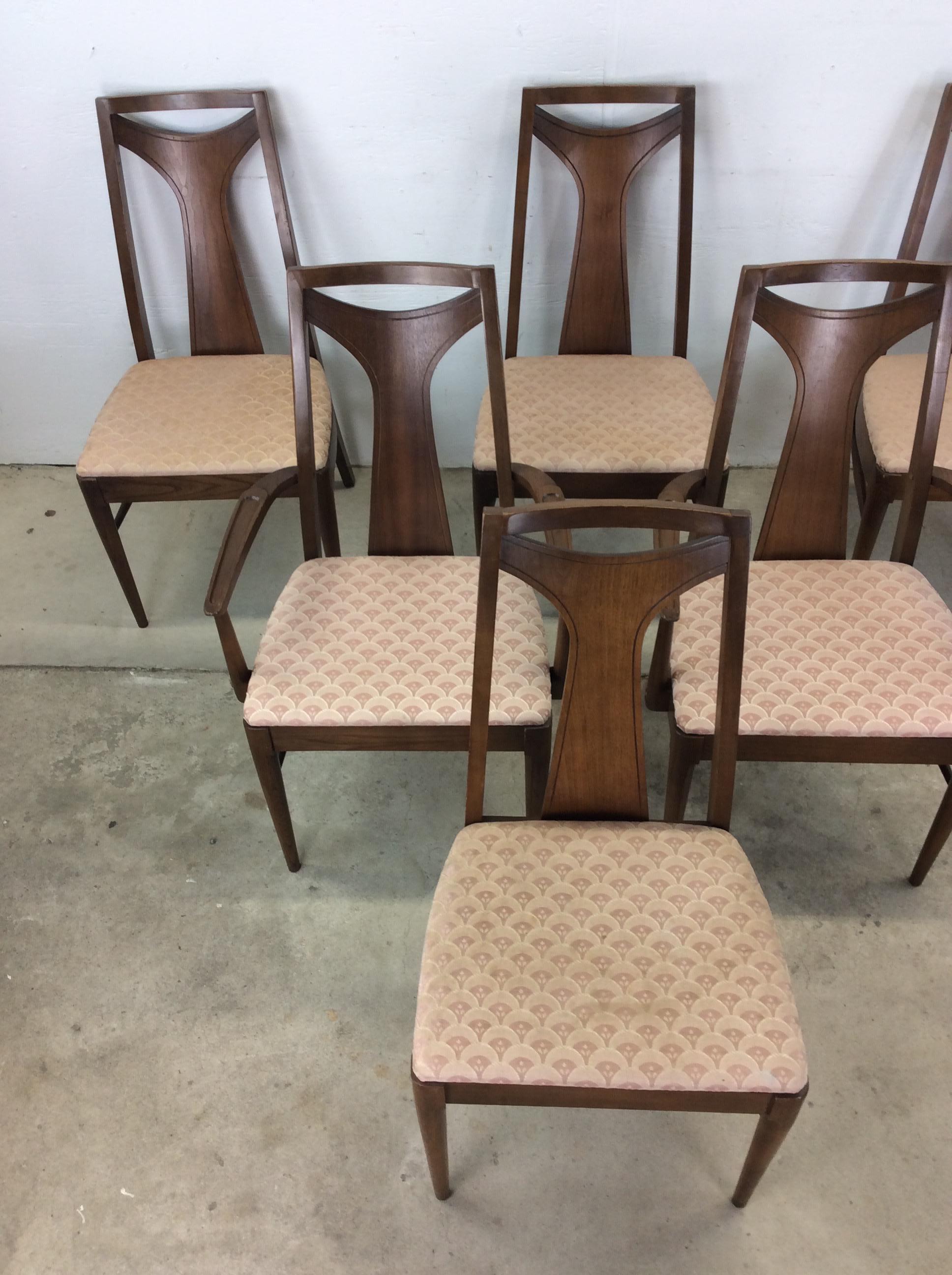 Questo set di sei sedie da pranzo moderne della metà del secolo è caratterizzato da una struttura in legno massiccio, una finitura originale in noce, un'imbottitura con motivi rosa vintage, uno schienale unico in legno curvato e alte gambe