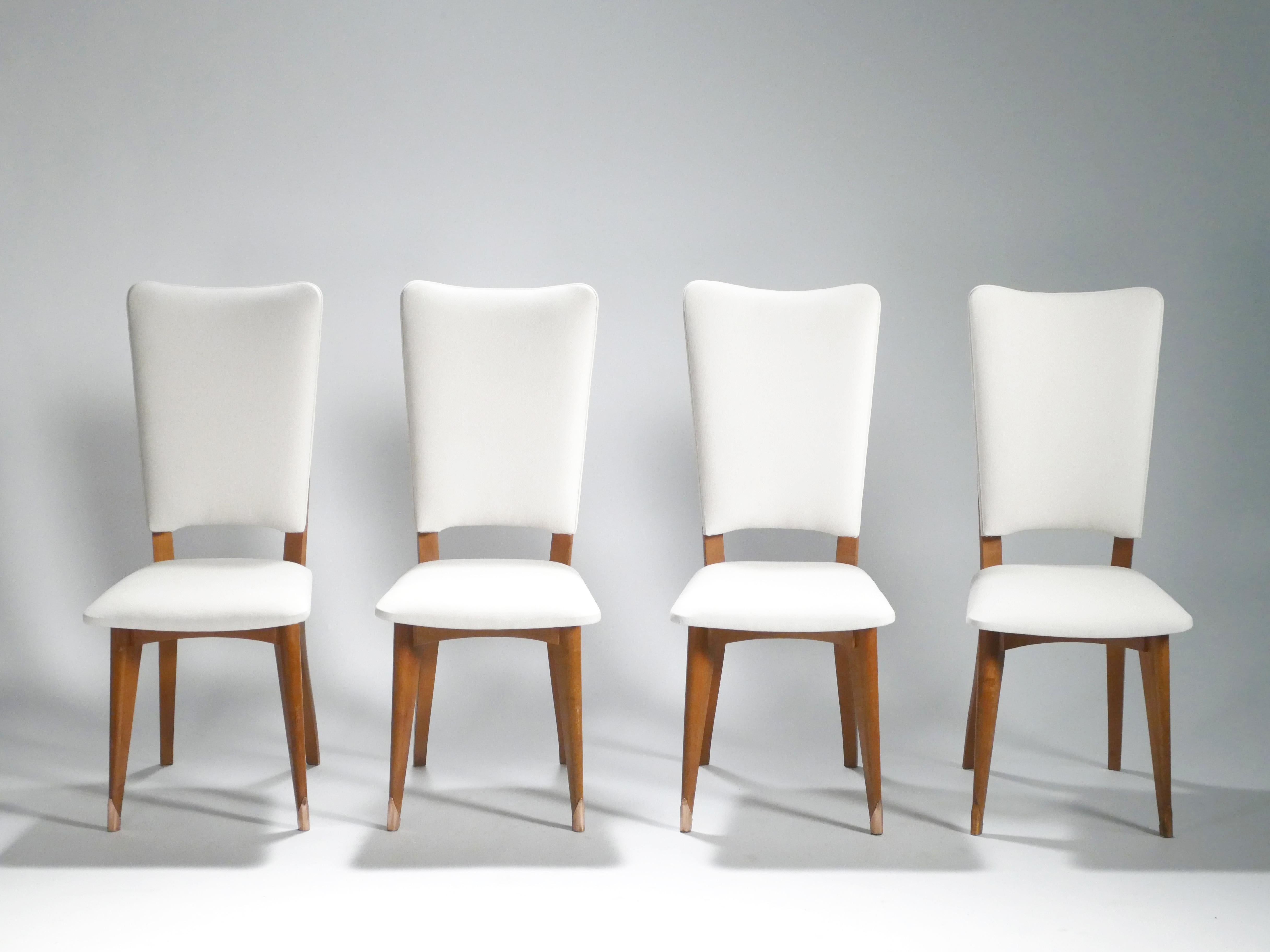 These 1960s chairs are examples of the widely admired elegant and chic Danish furniture design. With base and feet made from durable teak and new upholstery in superior, cool white Casamance fabric, these chairs’ simple, contrasting color scheme