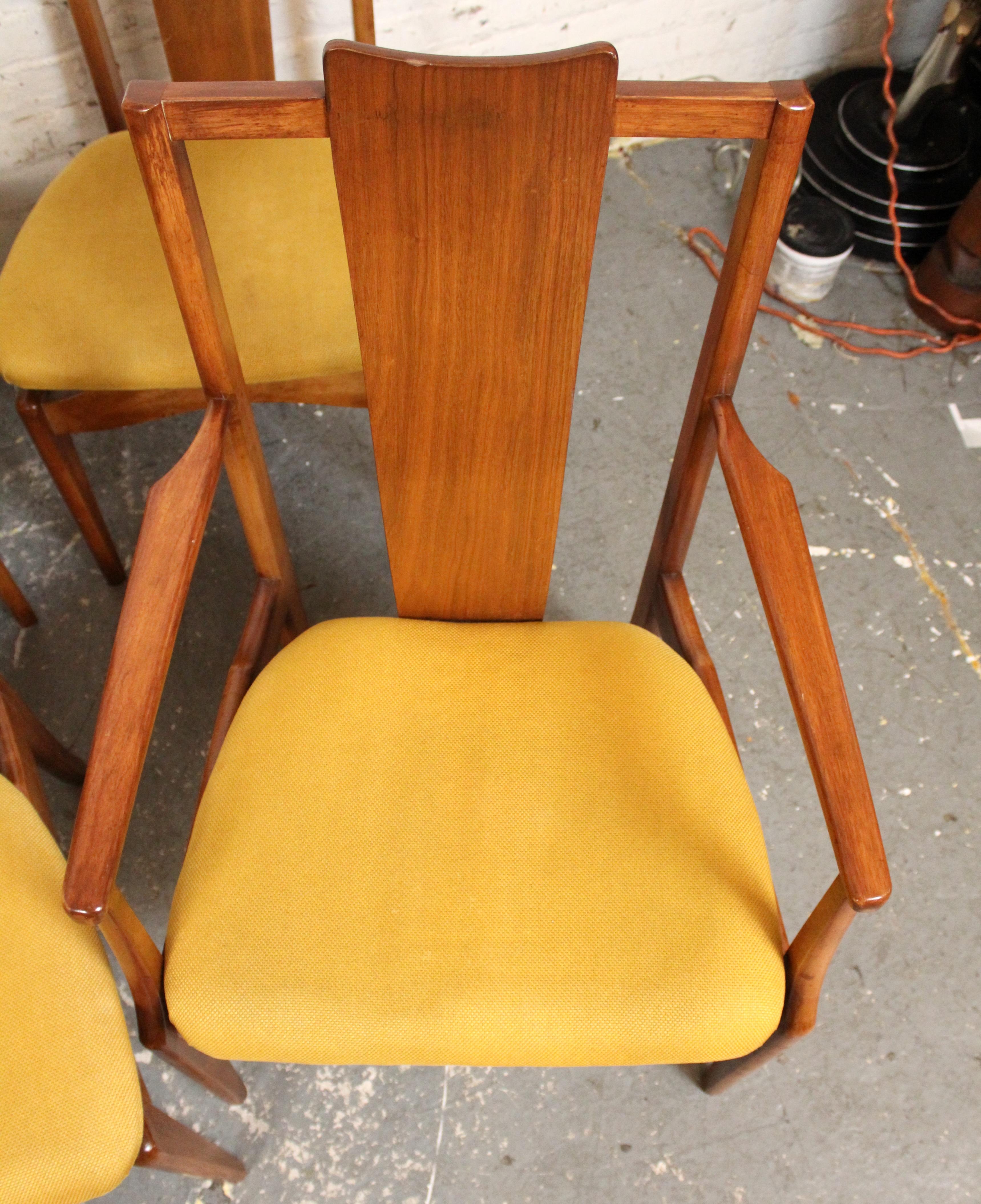 A striking set of six mid-century dining chairs by Young Manufacturing, crafted from solid walnut with a beautifully sculpted silhouette. This set includes two armchairs and four side chairs, each featuring a high, contoured backrest and warm